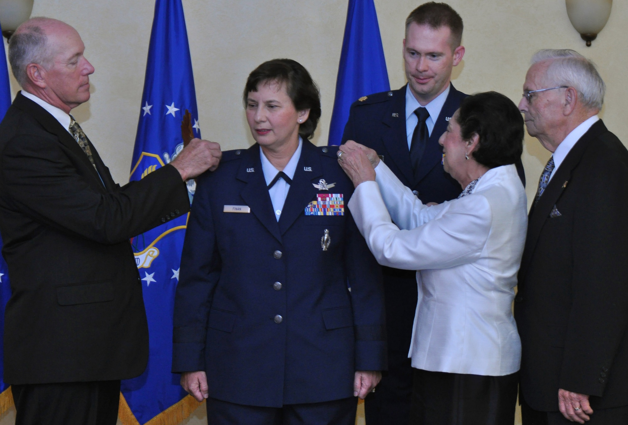 BARKSDALE AIR FORCE BASE, La. –Brig. Gen. Sandra Finan’s husband, Col. (ret) Chuck Finan (left), and her parents, Mrs. Margaret Chase and Mr. Delmar Chase, pin on her handmade brigadier general’s stars at her promotion ceremony June 15 at the Barksdale Club, as proffer Maj. Jonathan Davis looks on.  General Finan is the Air Force Global Strike Command Inspector General . (U.S. Air Force photo/Master Sgt. Corey Clements)