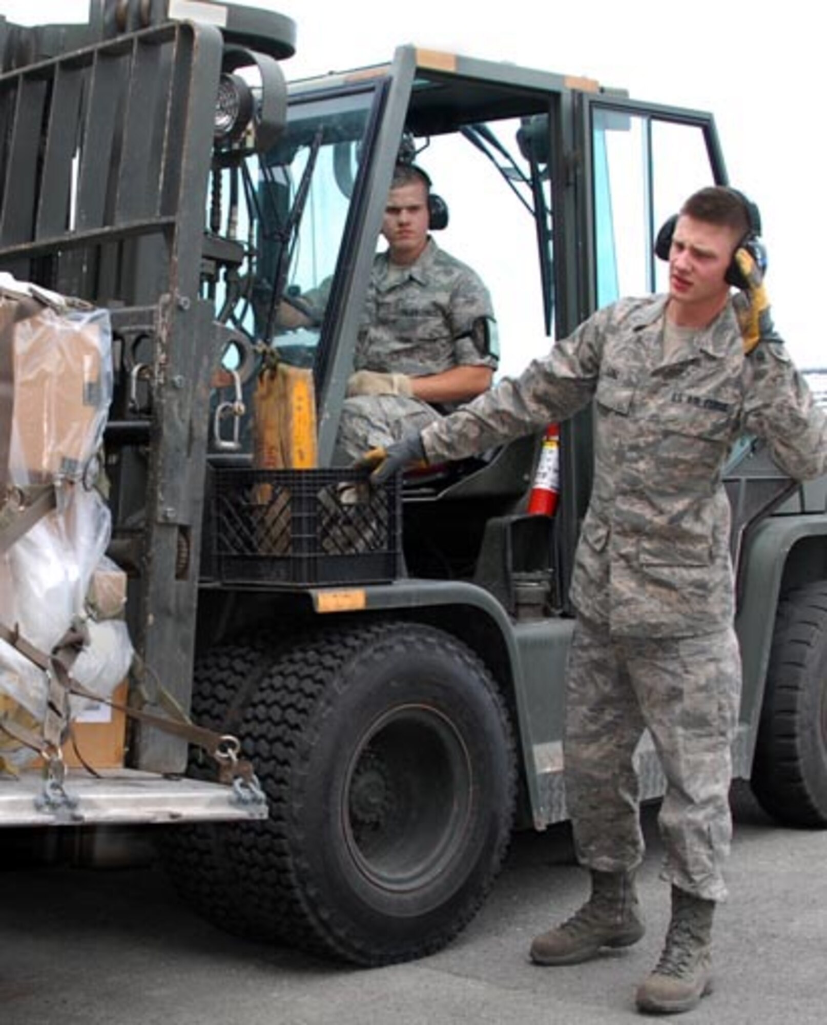 SrA David Williams drives the forklift while A1C Joseph Lenz guides him during the cargo build-up portion of the 176 LRS/ Aerial Port rodeo held Jun 12.