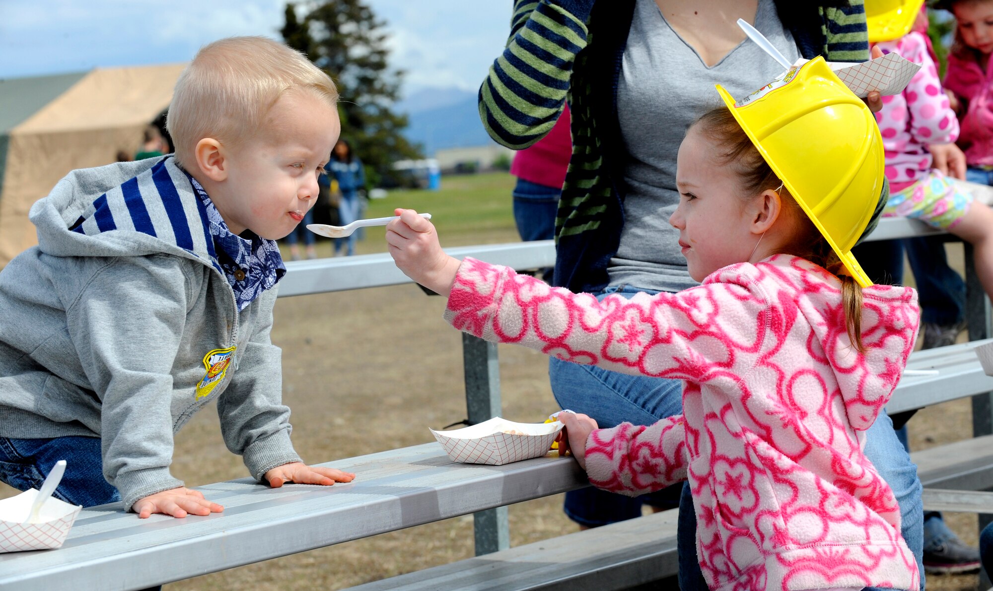 Grace Seiders, age 5, feeds her 2-year-old brother Averey ice cream during the Arctic Warrior Picnic, June 11.  The picnic is held every year to bring the community on Joint Base Elmendorf-Richardson together. (U.S. Air Force photo/Staff Sgt. Brian Ferguson)