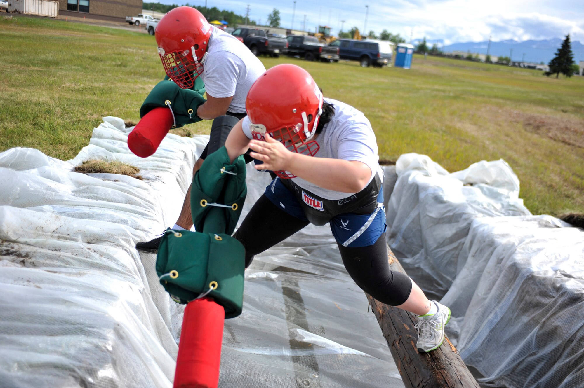 Service members fall off the log during a jousting match at the annual Arctic Warrior Olympics, June 11. In conjunction with the games, the Anchorage Chamber of Commerce held their annual Military Appreciation Picnic for service members and their families stationed on the installation. (U.S. Air Force photo/Airman 1st Class Christopher Gross)