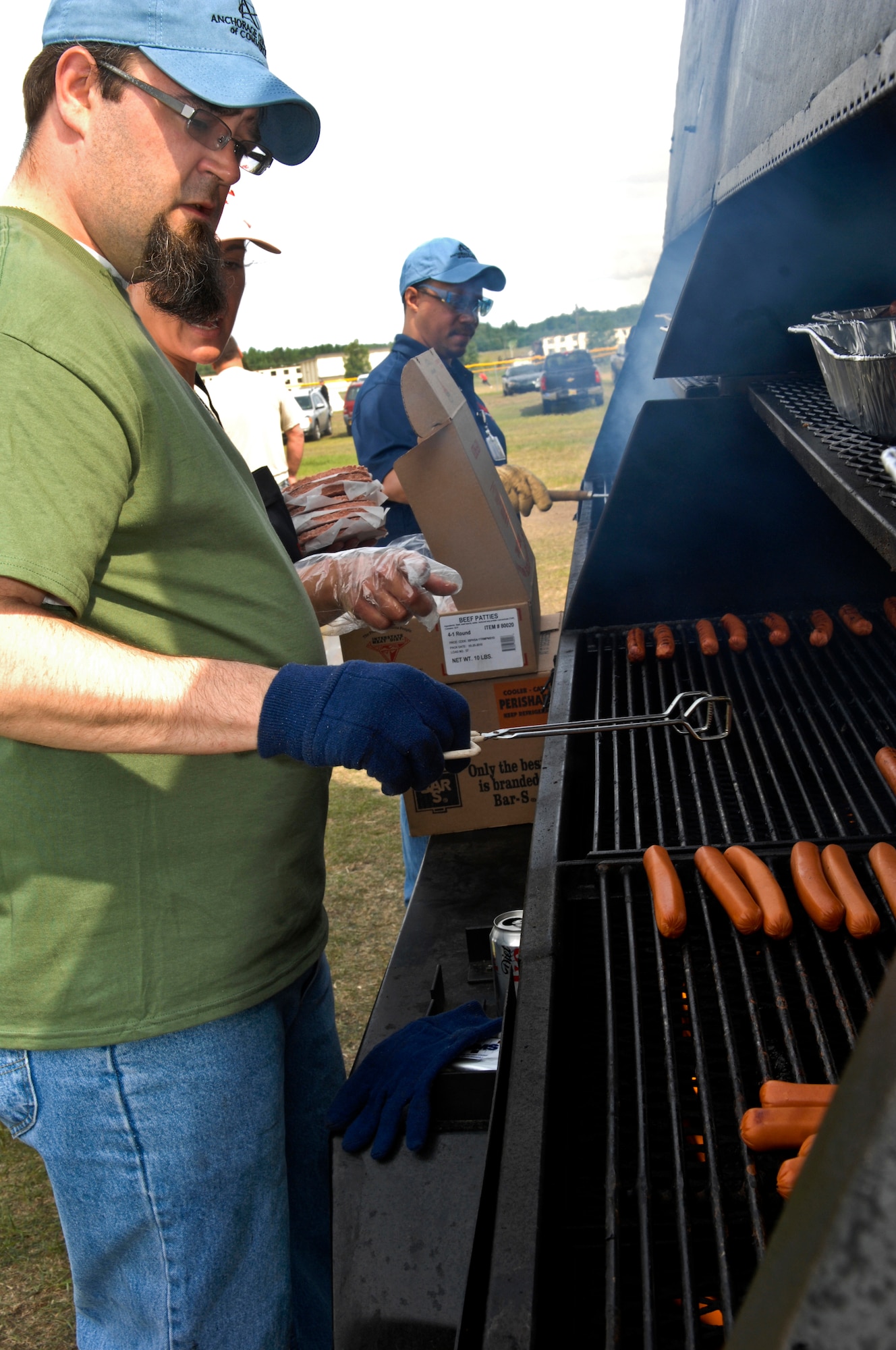 Mr. Tony Flynn, a volunteer with Northern Air Cargo, grills food for the Arctic Warrior Picnic, June 11. The Arctic Warrior Picnic is held every June to bring the community on Joint Base Elmendorf-Richardson together. (U.S. Air Force photo/Airman 1st Class Jack Sanders)