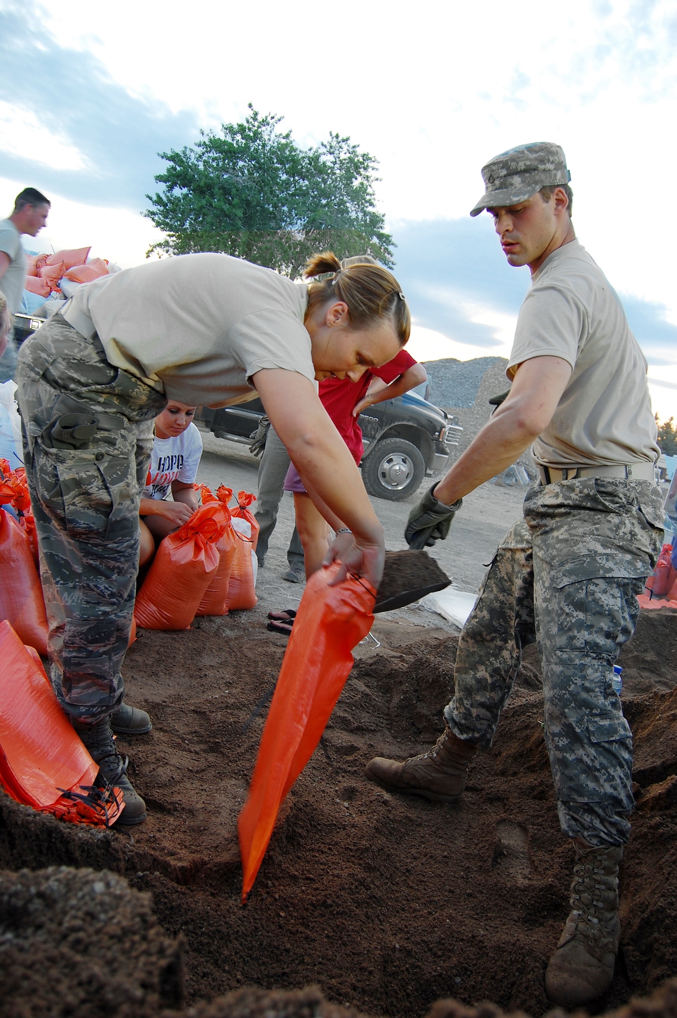 Staff Sgt. Niki Label and Pfc. Taylor Carlson fill sandbags to aid in stopping the rising flood waters of the Popo Agie River, June 11, 2010, in Fremont County, Wyo. Sergeant Label is assigned to the Wyoming Air National Guard's 187th Aeromedical Evacuation Squadron. Private Carlson is assigned to the Wyoming Army National Guard's A Battery, 2-300th Field Artillery. (Photo by Christian Venhuizen)