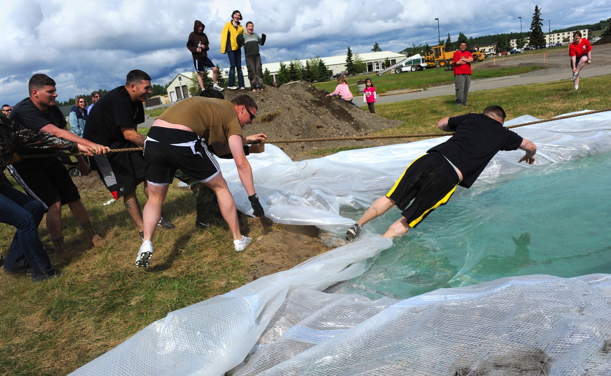 An Airman from the 3rd Security Forces Squadron plunges into the water after losing a round in the tug-o-war during the Arctic Warrior Olympics, June 11. The Arctic Warrior Olympics are held every June to bring the community on Joint Base Elmendorf-Richardson together. (Air Force photo by Senior Airman Cynthia Spalding)
