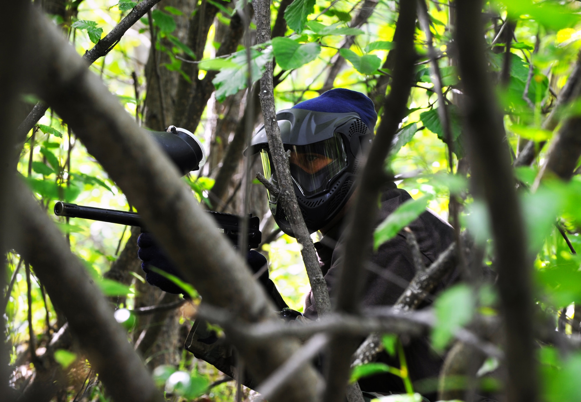 Airman 1st Class Jeremy Young waits in the woods for an opportunity to take out an opponent during a game of paintball at the Arctic Warrior Olympics, June 11. The Arctic Warrior Olympics are held every June to bring the community on Joint Base Elmendorf-Richardson together. Airman Young is a contracting specialist with the 3rd Contracting Squadron. (Air Force photo by Senior Airman Cynthia Spalding)
