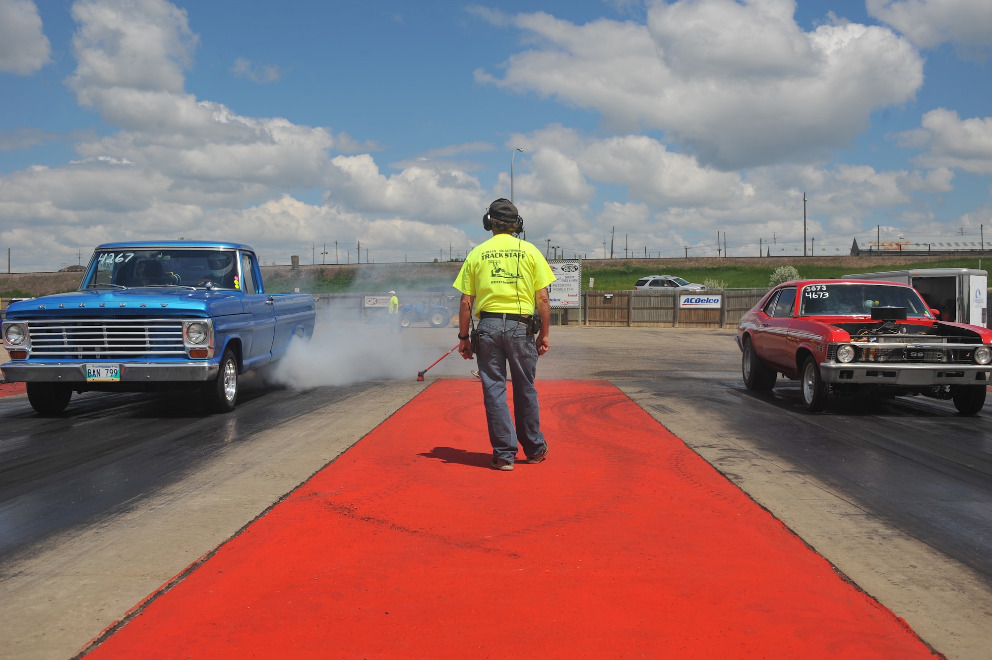 MINOT, N.D. -- Two vehicles start a burnout before their race at the Magic City International Dragway here June 13. Street, modified and top ET cars, along with street or custom motorcycles and snowmobiles are encouraged to practice during test and tune runs and to race at the MCID. (U.S. Air Force photo by Master Sgt. Michael Gaddis)