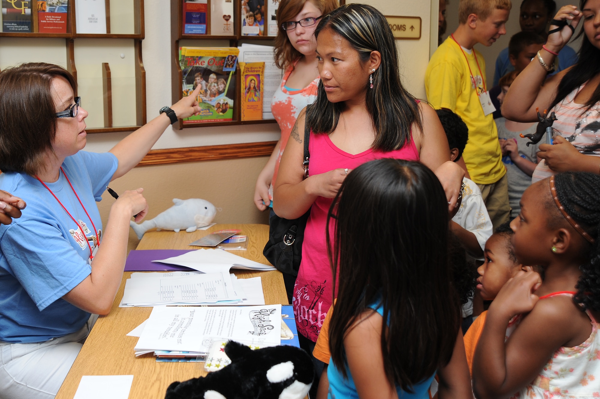 Heather Scott, Team McConnell family member, directs Team McConnell families on where to go for Vacation Bible School at the base chapel on June 14, 2010, McConnell Air Force Base, Kan.  More than 75 Team McConnell children from pre-Kindergarten through sixth grade registered for VBS.  During this year’s VBS, themed “High Seas Expedition: Exploring the mighty love of God,” children participated in biblical themed activities.  The chapel hosted Vacation Bible School for children from 6 to 8 p.m. June 14 to 18. (U.S. Air Force photo/Tech. Sgt. Chyrece Campbell) 