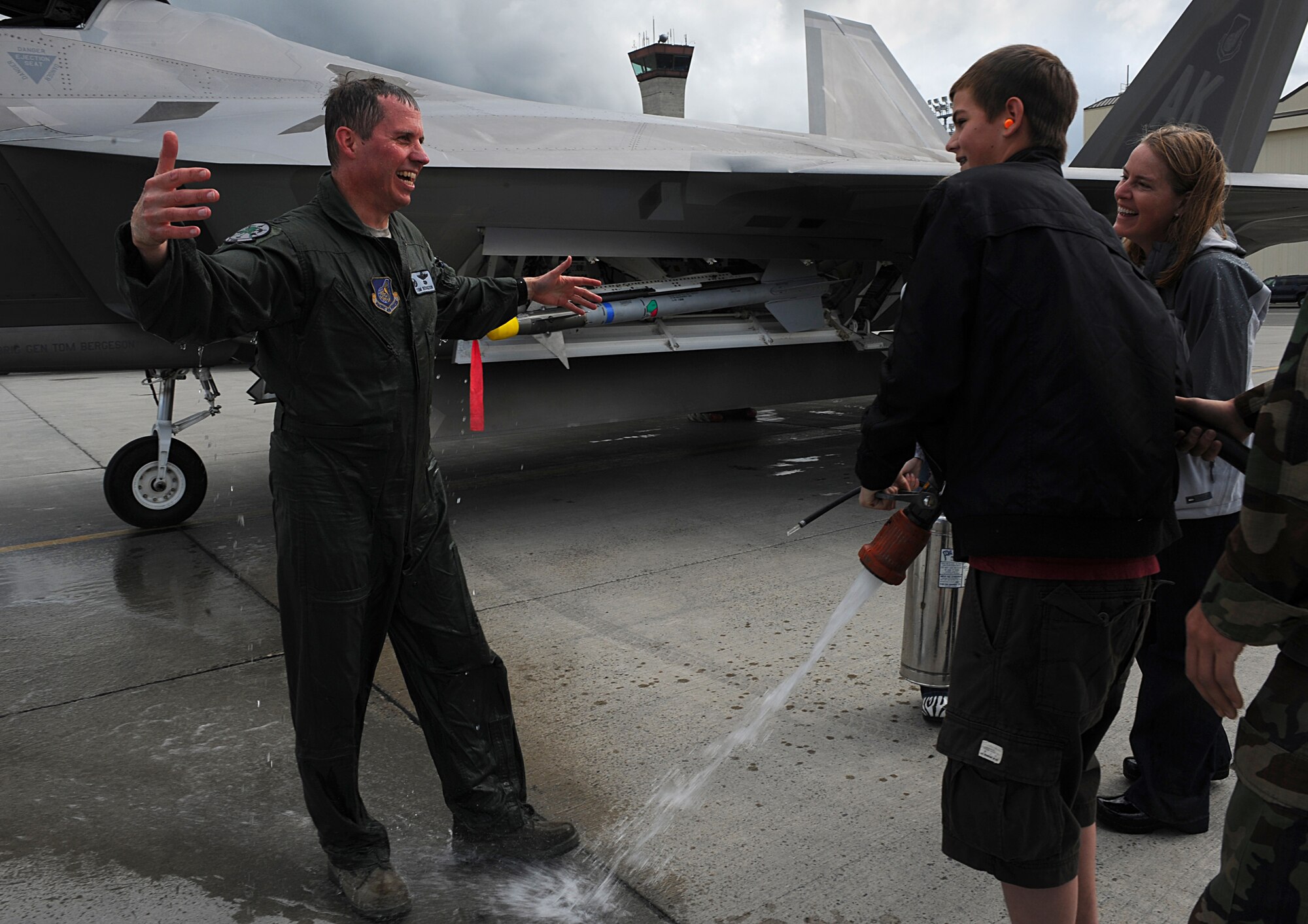 Brig. Gen. Thomas Bergeson, 3rd Wing commander, reaches to hug his son, Erik, 13, after returning from his fini-flight June 10. General Bergeson was greeted by his family with champagne and water after he exited the F-22 Raptor. (Air Force photo by Senior Airman Cynthia Spalding)