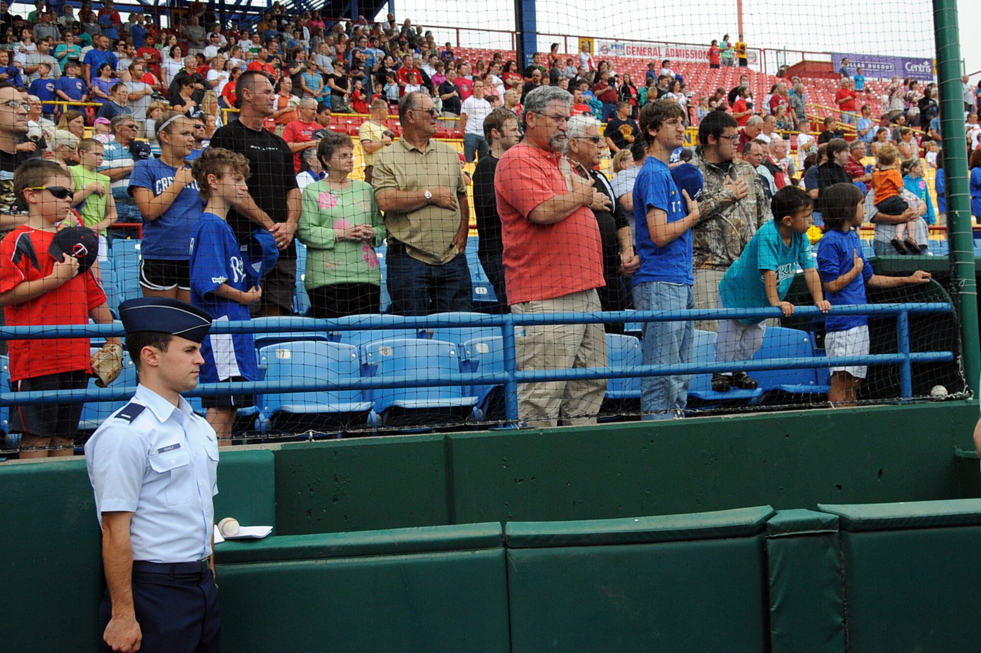 Offutt Air Force Base, Neb. --- First Lt. Ken Scholz, 55th Wing Public Affairs, community relations chief, stands at attention during the singing of the National Anthem at the annual Military Appreciation Game June 13 at Rosenblatt Stadium. The Omaha Royals played the Nashville Sounds in front of a crowd of military members and their families. The Royals beat the Sounds  two to one to take the four game series three games to one. 