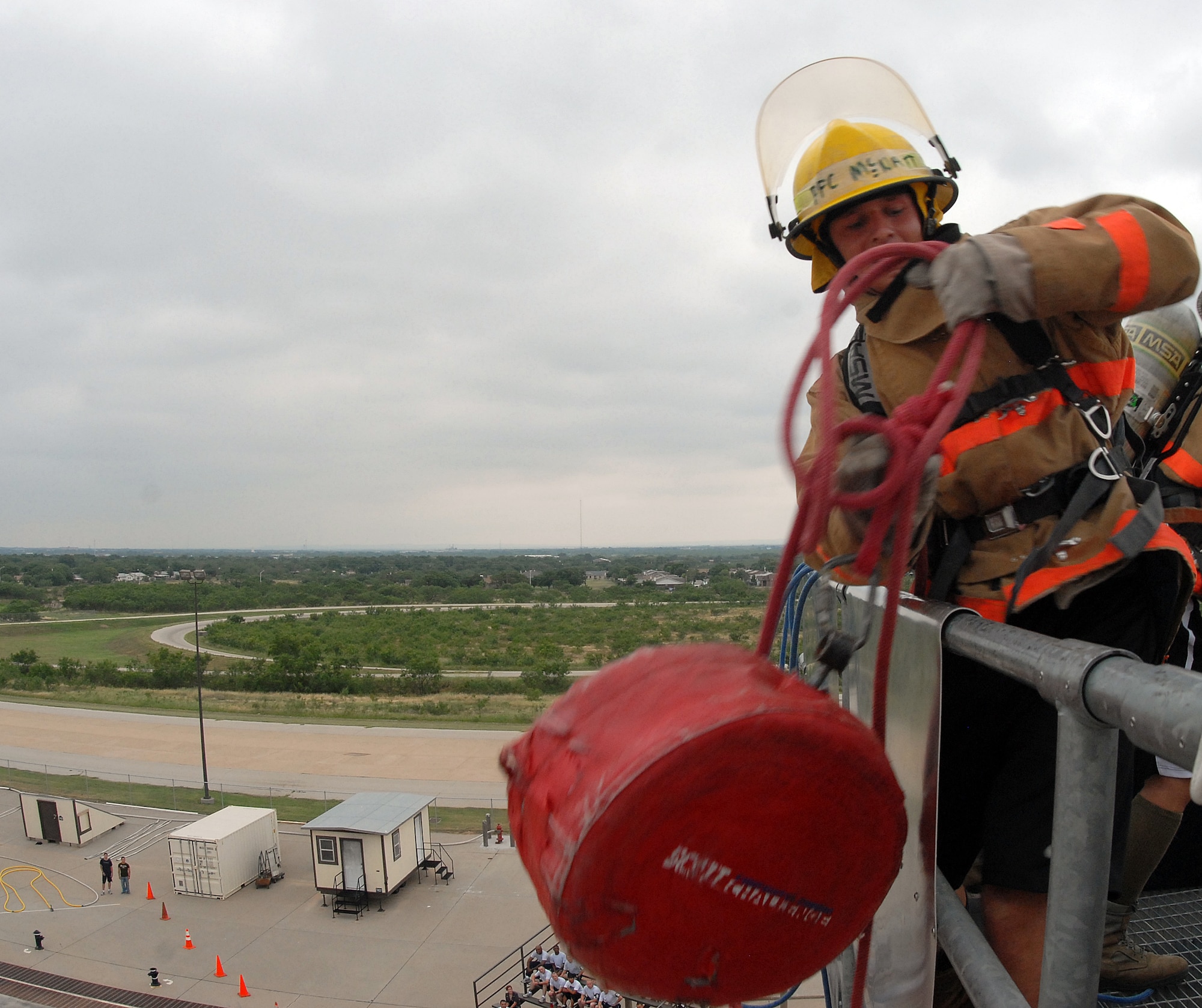 A competitor pulls up 42 pound weight up five stories during the 2nd quarter Goodfellow AFB Rookie Firefighter Challenge June 12 This is just one leg of a relay that is call the toughest two minutes in sports which pushes teams and individuals to their physical limits.(U.S. Air Force photo/Master Sgt Randy Mallard)