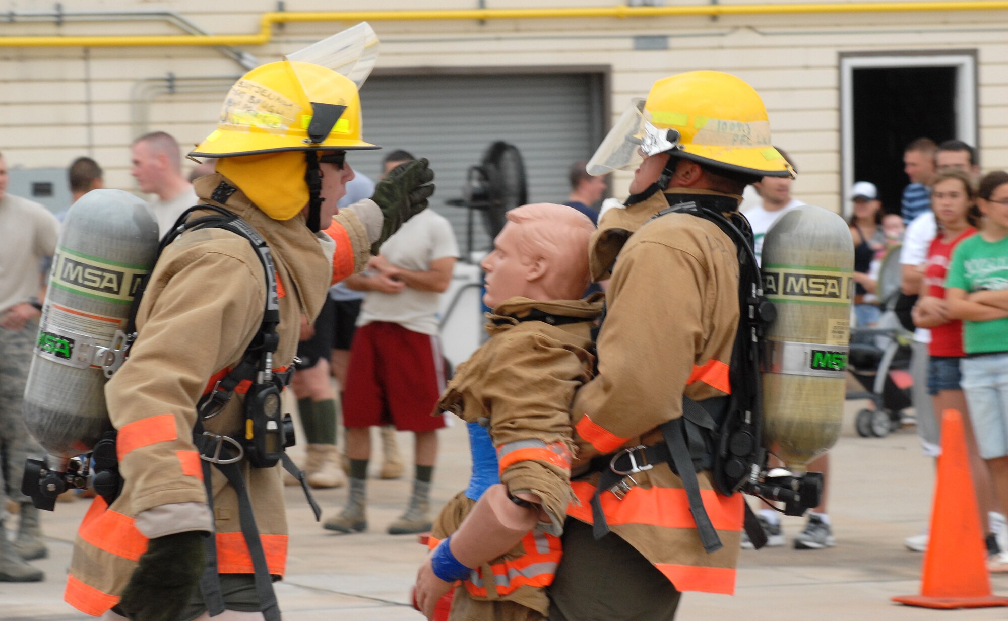 A competitor provides over watch for his team member as he drags a “victim” 100 feet to a predetermined location during the 2nd quarter Goodfellow AFB Rookie Firefighter Challenge June 12.  This is just one leg of a relay that is call the toughest two minutes in sports which pushes teams and individuals to their physical limits. (U.S. Air Force photo/Master Sgt Randy Mallard)