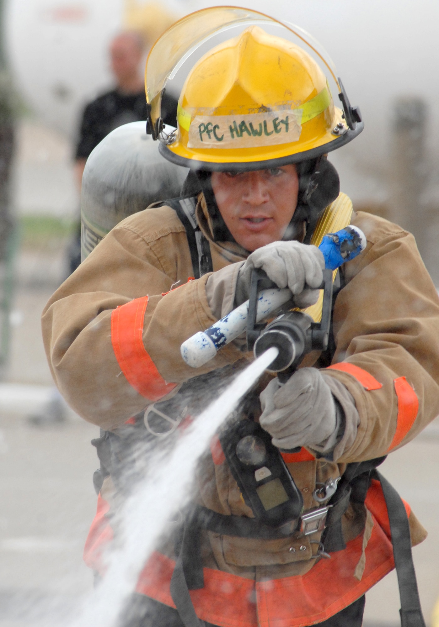 A competitor drags a hose 75 feet to a predetermined location in order to knock down a target with a stream of water during the 2nd quarter Goodfellow AFB Rookie Firefighter Challenge June 12.  This is just one leg of a relay that is call the toughest two minutes in sports which pushes teams and individuals to their physical limits. (U.S. Air Force photo/Master Sgt Randy Mallard)
