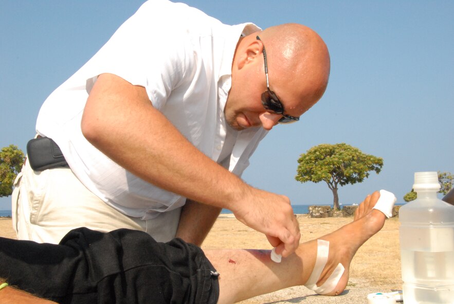 Master Sgt. Donnie Diller, a public health craftsman with the 178th Medical Group, Ohio Air National Guard, disinfects local Ed Rosen's wounds June 10 at Old Kona Airport State Recreation Area, Hawaii.  This was part of the 178 MDG's medical training deployment in which it provides free medical services to underserved Kona communities June 7-17.