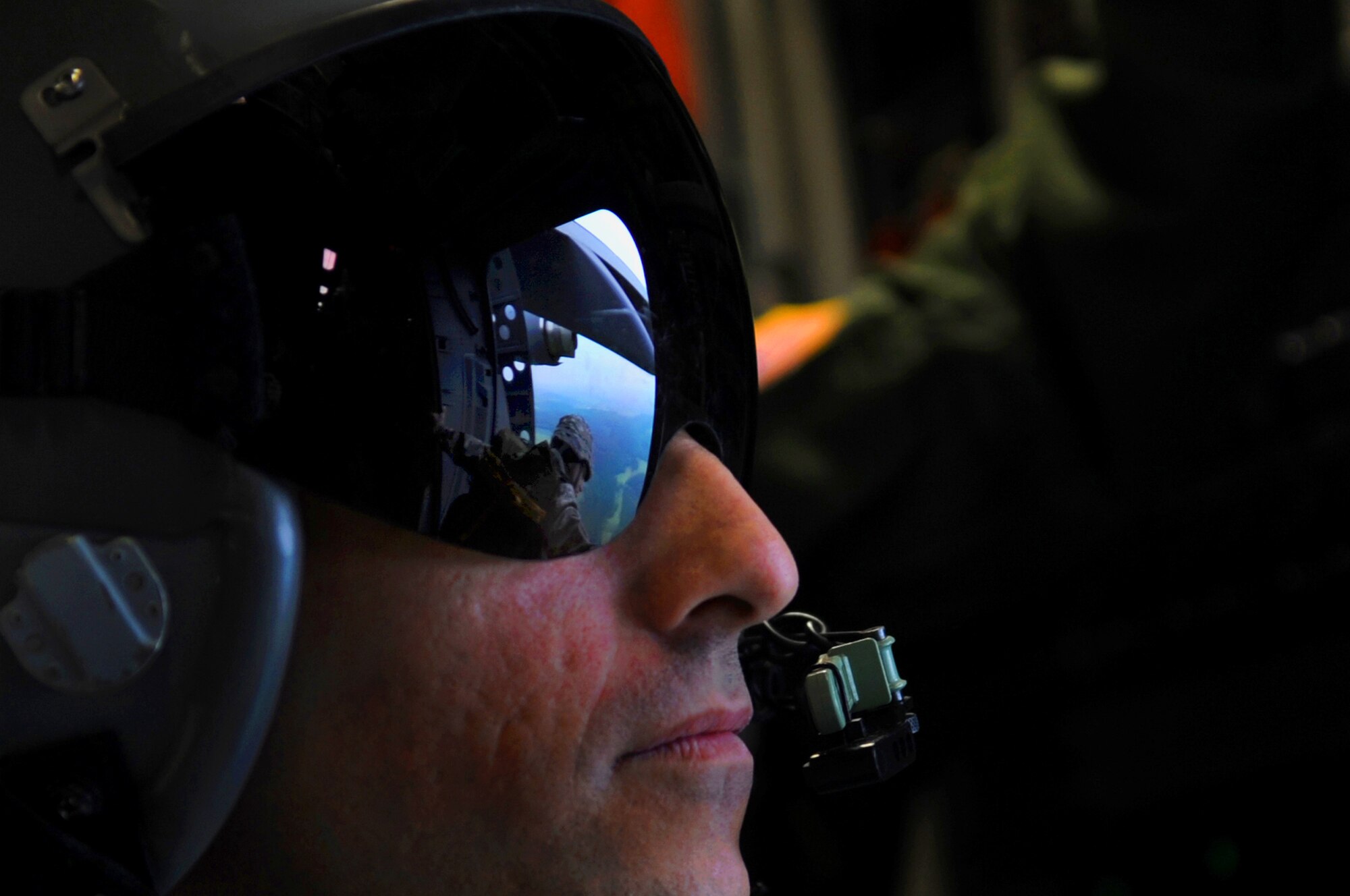 Master Sgt. Jason Brown watches a jumpmaster perform his checks before executing an airborne jump over the drop zone in Alzey, Germany, June 14, 2010. Five NATO countries participated in the annual event to support one of U. S. Air Forces in Europe's top priorities, building partnerships. Sergeant Brown is a loadmaster with the Heavy Airlift Squadron at Papa Air Base, Hungary. (U.S. Air Force photo/Airman 1st Class Grovert Fuentes-Contreras)