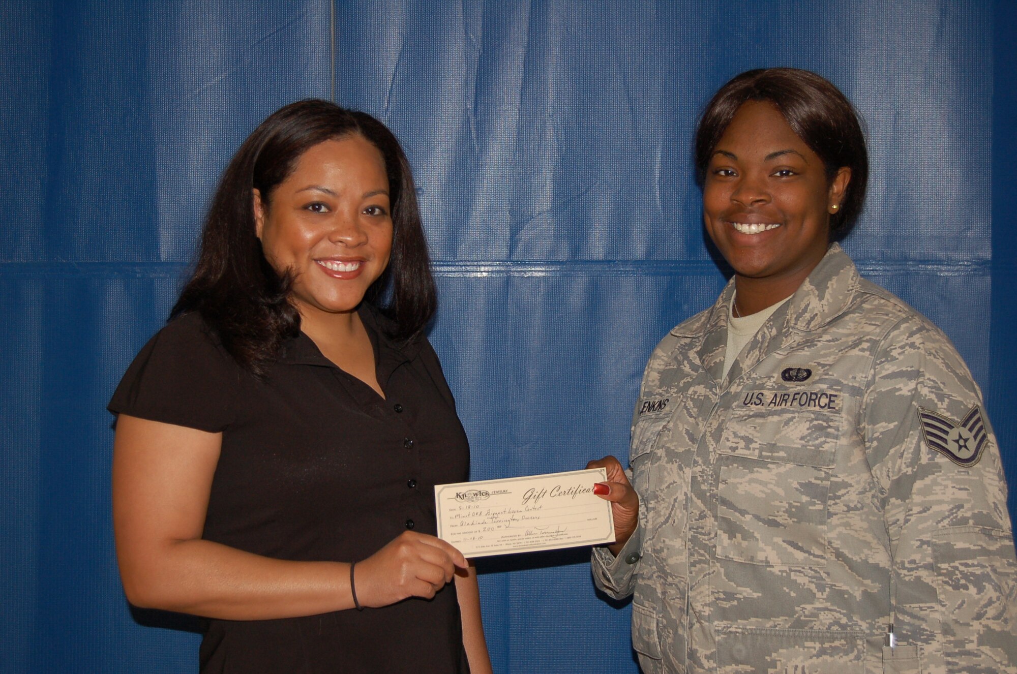 MINOT AIR FORCE BASE, N.D. -- Elise Jones receives her $200 Knowles Jewelry gift certificate from Staff Sgt. Kenyata Jenkins, 5th Force Support Squadron fitness center program manager, after being named the overall winner in the female category of the 2010 “Biggest Loser” competition May 28.  Ms. Jones topped the category with 6.4 percent body fat loss and lost 13 pounds. (Courtesy photo by Debra Vangsness)