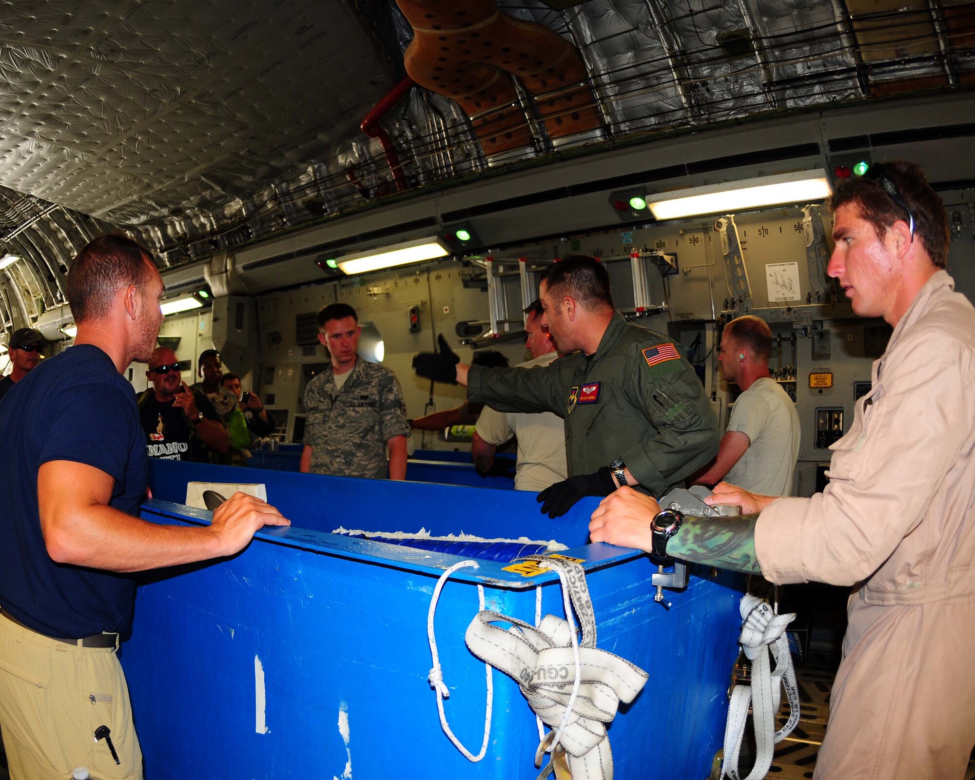 ALTUS AFB, Okla.- Tech. Sergeant Douglas Campbell, a loadmaster from the 58th Airlift Squadron, directs members of the U.S. Navy Marine Mammal Fleet as they prepare to fly four bottlenose dolphins from Norfolk Naval Station, Virginia to Point Loma Sub Base, San Diego, California June 14. The dolphins were in Norfolk for two weeks participating in the multinational exercise called Frontier Sentinel. (U.S. Air Force photo/Senior Airman Leandra D. Hernandez)