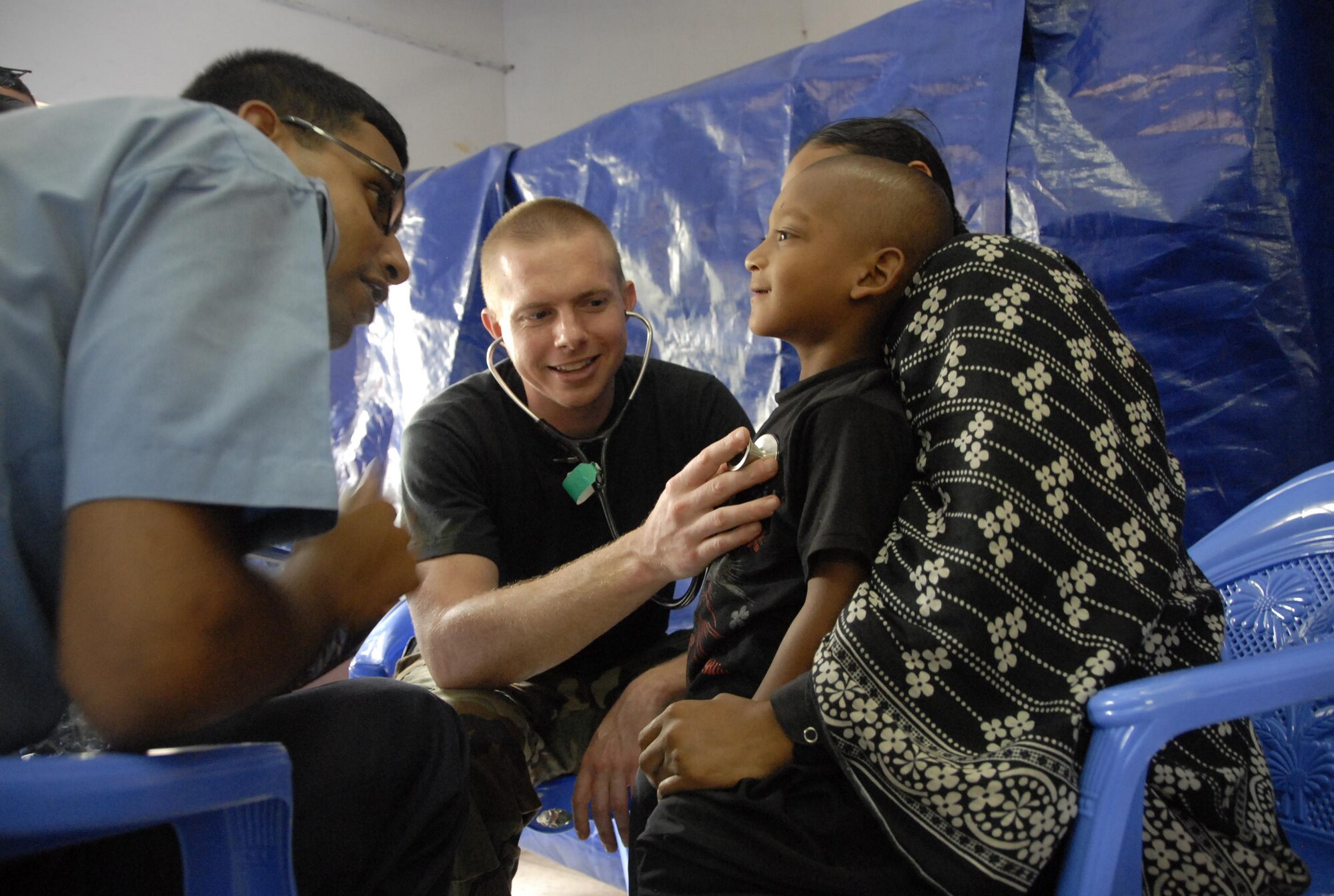 Capt. David Belcher (center), a general care physician from the 3rd Medical Group at Elmendorf Air Force Base, Alaska,  examines a young Bangladeshi boy while a translator from the Bangladesh Air Force speaks with the patient in Jessore, Bangladesh, as part of Operation Pacific Angel on June 13, 2010.  Operation Pacific Angel is a joint and combined humanitarian assistance operation conducted in the Pacific area of responsibility to support U.S. Pacific Command's capacity-building efforts. This humanitarian and civic assistance program is aimed at improving military civic cooperation between the United States and countries throughout the Asia-Pacific region. More than 55 U.S. military personnel are participating in civil and medical assistance programs with the help of the Bangladesh Air Force and local nongovernmental organizations. Medical care for Bangladesh citizens will include: primary care, women's health, dental and optometry. Several classrooms are being refurbished as part of the mission at the Lauri High School and Primary School. The operation is scheduled through June 16, 2010. (U.S. Air Force photo/1st Lt. Chris Hoyler)

 