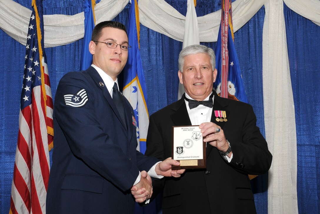 McGHEE TYSON AIR NATIONAL GUARD BASE, Tenn. -- Tech. Sgt. Brandon K. Sheldon, left, a member of the California Air National Guard, receives the distinguished graduate award for NCO Academy Class 10-5 at The I.G. Brown Air National Guard Training and Education Center here from retired Chief Master Sergeant Richard A. Moon, fifth ANG Senior Enlisted Advisor, June 2, 2010. The distinguished graduate award is presented to students in the top ten percent of the class.  It is based on objective and performance evaluations, demonstrated leadership, and performance as a team player. (U.S. Air Force photo by Master Sgt. Kurt Skoglund/Released)