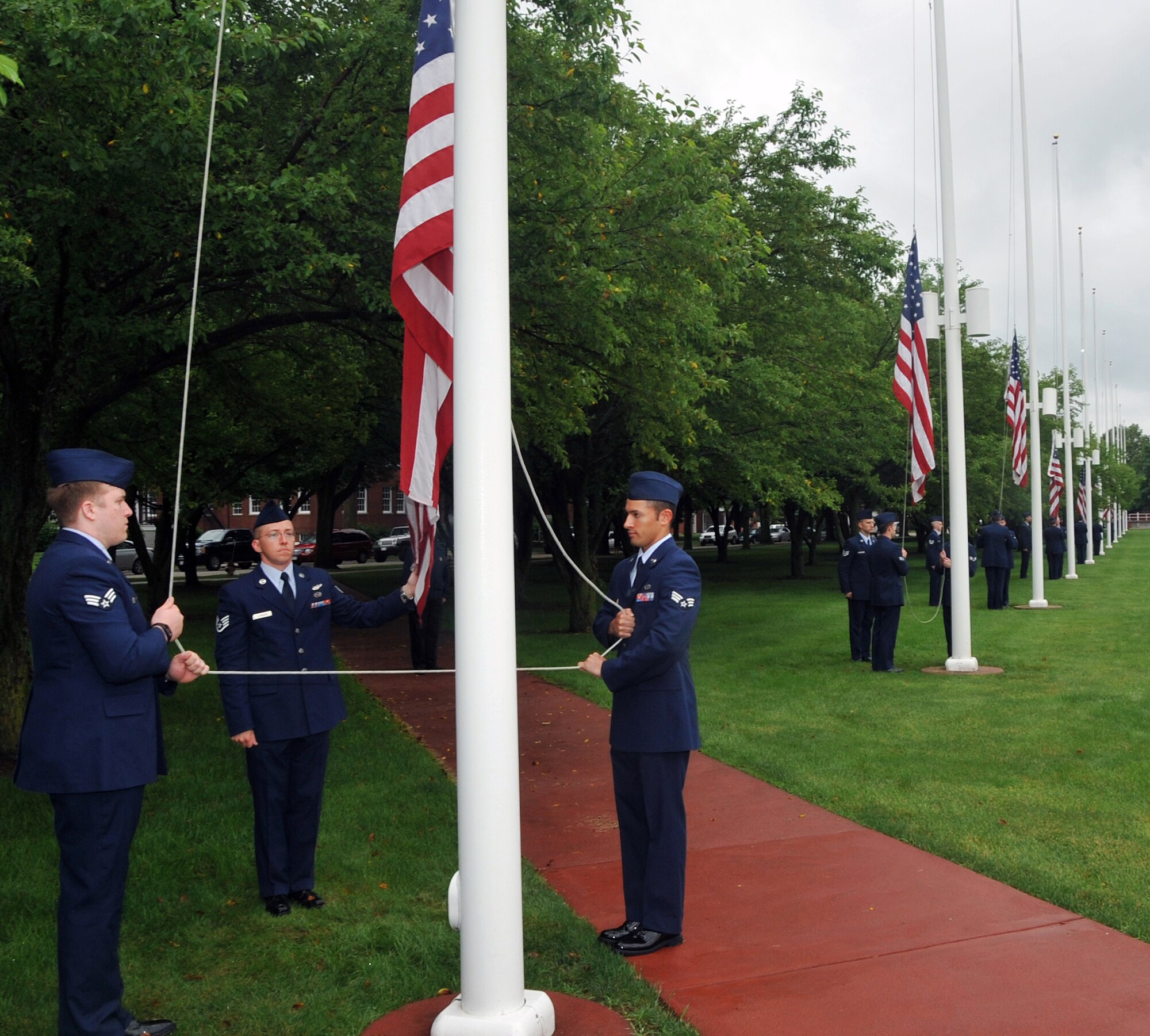 OFFUTT AIR FORCE BASE, Neb. -- Staff Sgt. Timothy Landson and Senior Airmen Aubrey Hudson and Jason Davidson from the 97th Intelligence Squadron raise the Stars and Stripes during a Flag Day ceremony at the Offutt Parade Grounds June 14. Members from across Team Offutt gathered to raise multiple American flags lining the Parade Grounds during the ceremony which also included poetry readings and the singing of patriotic songs by a local acapella group. U.S. Air Force Photo by Jeff W. Gates
