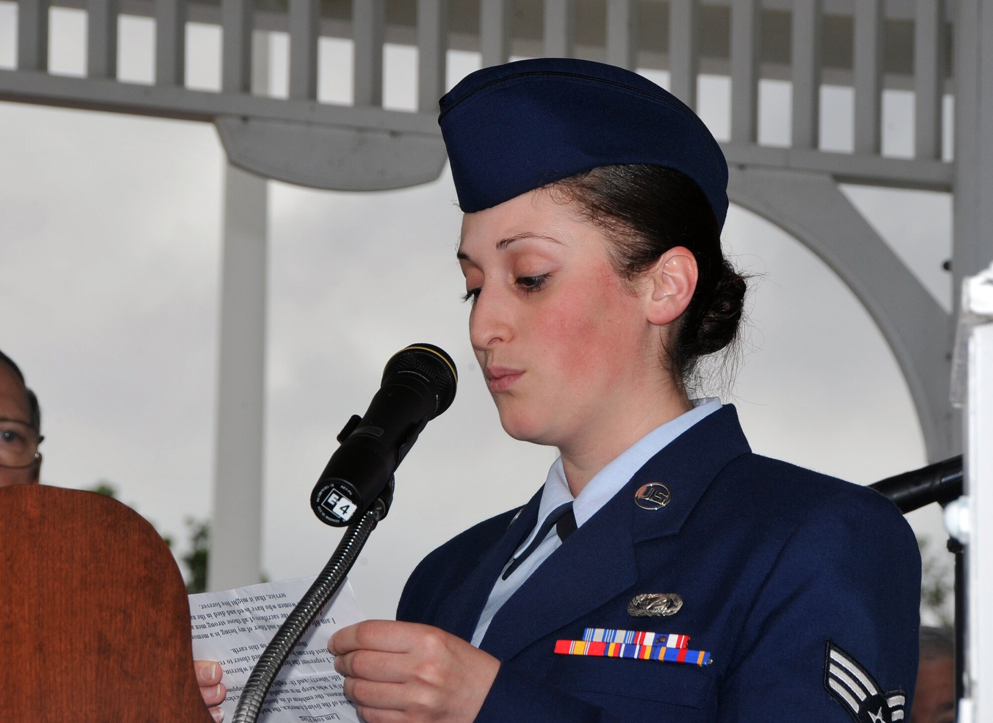 OFFUTT AIR FORCE BASE, Neb. -- Senior Airman Jennifer Santos from the 55th Maintenance Group reads a few words during a ceremony at the Offutt Parade Grounds honoring Flag Day June 14. Members from across Team Offutt gathered to raise multiple American flags lining the Parade Grounds during the ceremony which also included the singing of patriotic songs by a local acapella group. U.S. Air Force Photo by Jeff W. Gates 