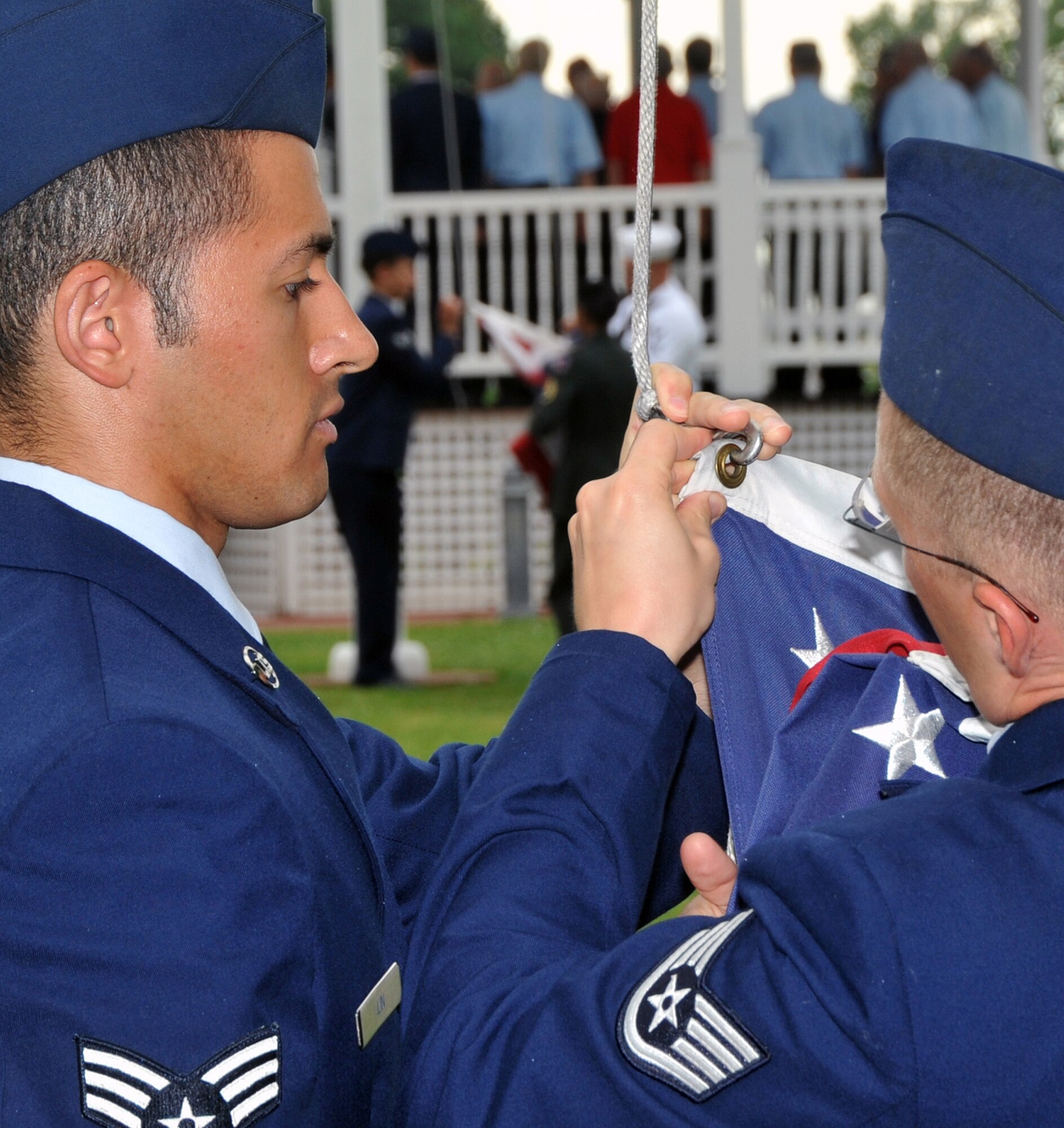 OFFUTT AIR FORCE BASE, Neb. -- OFFUTT AIR FORCE BASE, Neb. -- Staff Sgt. Timothy Landson and Senior Airman Jason Davidson from the 97th Intelligence Squadron connect Old Glory to a flag pole before raising it for Flag Day. Members from across Team Offutt gathered to raise multiple American flags lining the Parade Grounds during Offutt's Flag Day ceremony June 14. The ceremony also included poetry readings and the singing of patriotic songs by a local acapella group. U.S. Air Force Photo by Jeff W. Gates