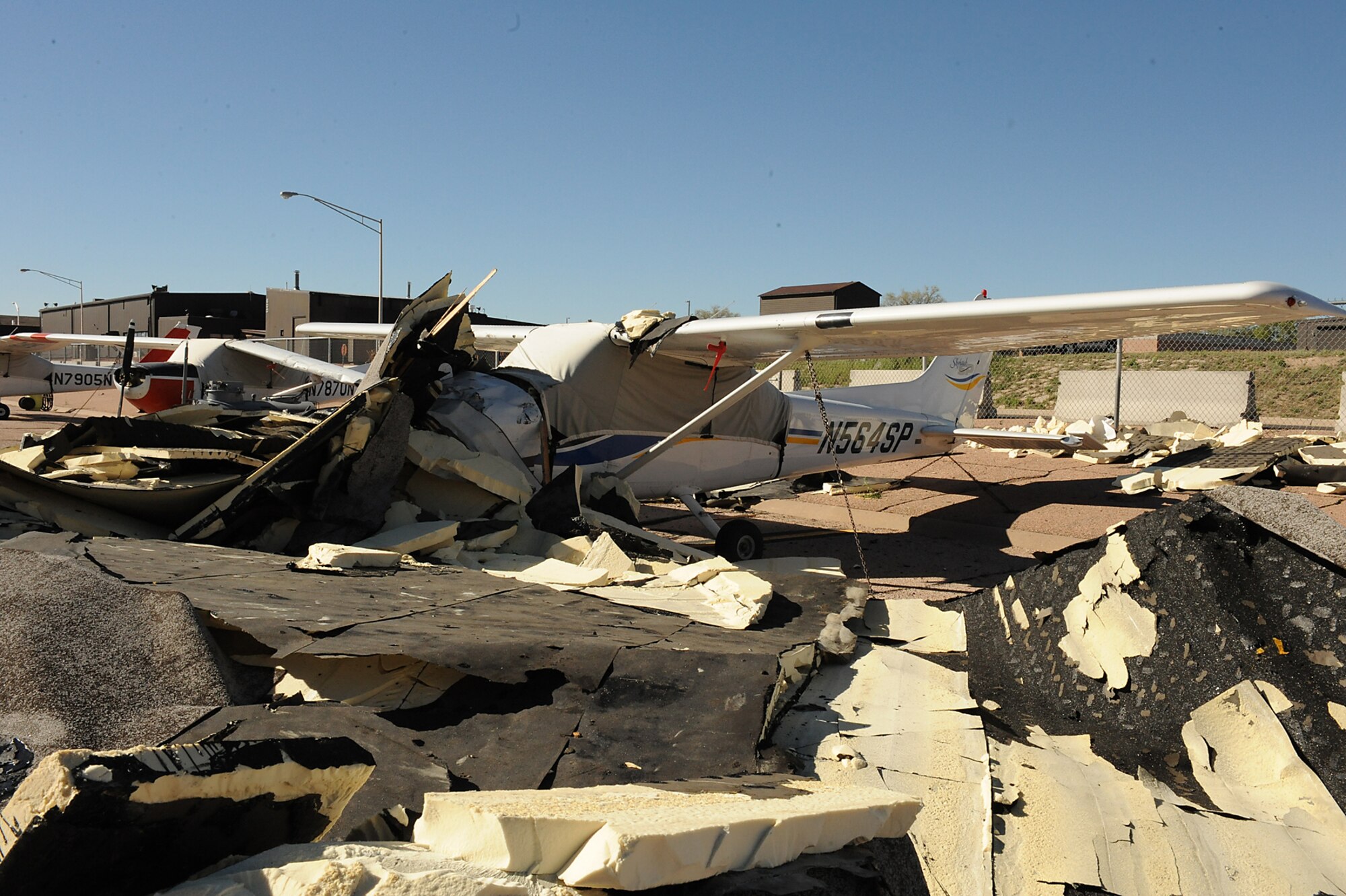 On May 25, 60 mph winds ripped half the roof off Hangar 133 on the Peterson Air Force Base flightline and the debris landed atop two of the Aero Club’s Cessna airplanes. One plane suffered a broken spine, bent engine mounts and wing damage. Club officials expect it to be ruled a total loss by the insurance company. A second aircraft suffered strut and wing damage, but has been repaired and is back in the air. (U.S. Air Force photo/Roberta McDonald) 