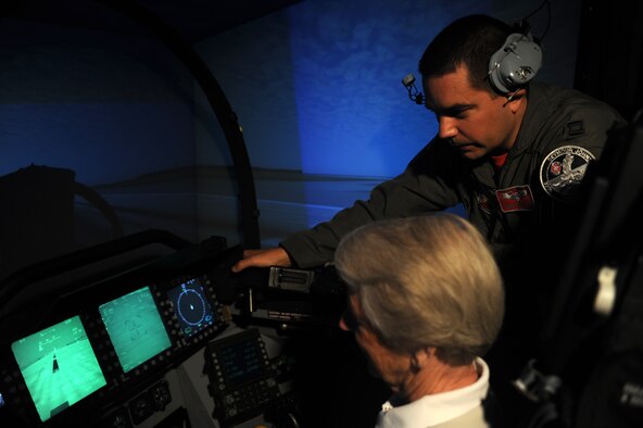 SEYMOUR JOHNSON AIR FORCE BASE, N.C. -- Capt. Nathan White assists Kris Frankfurt in a flight simulator during the Air Force Civic Leader Alumni Group base tour here June 11, 2010. The machine simulates what it would be like to fly an F-15E Strike Eagle and is used as initial training for Basic Course students and refresher training for seasoned pilots and weapons system officers. Captain White is a WSO with the 333rd Fighter Squadron. Mrs. Frankfurt is the wife of Bill Frankfurt, a civic leader from Oklahoma City. (U.S. Air Force photo/Staff Sgt. Heather Stanton)