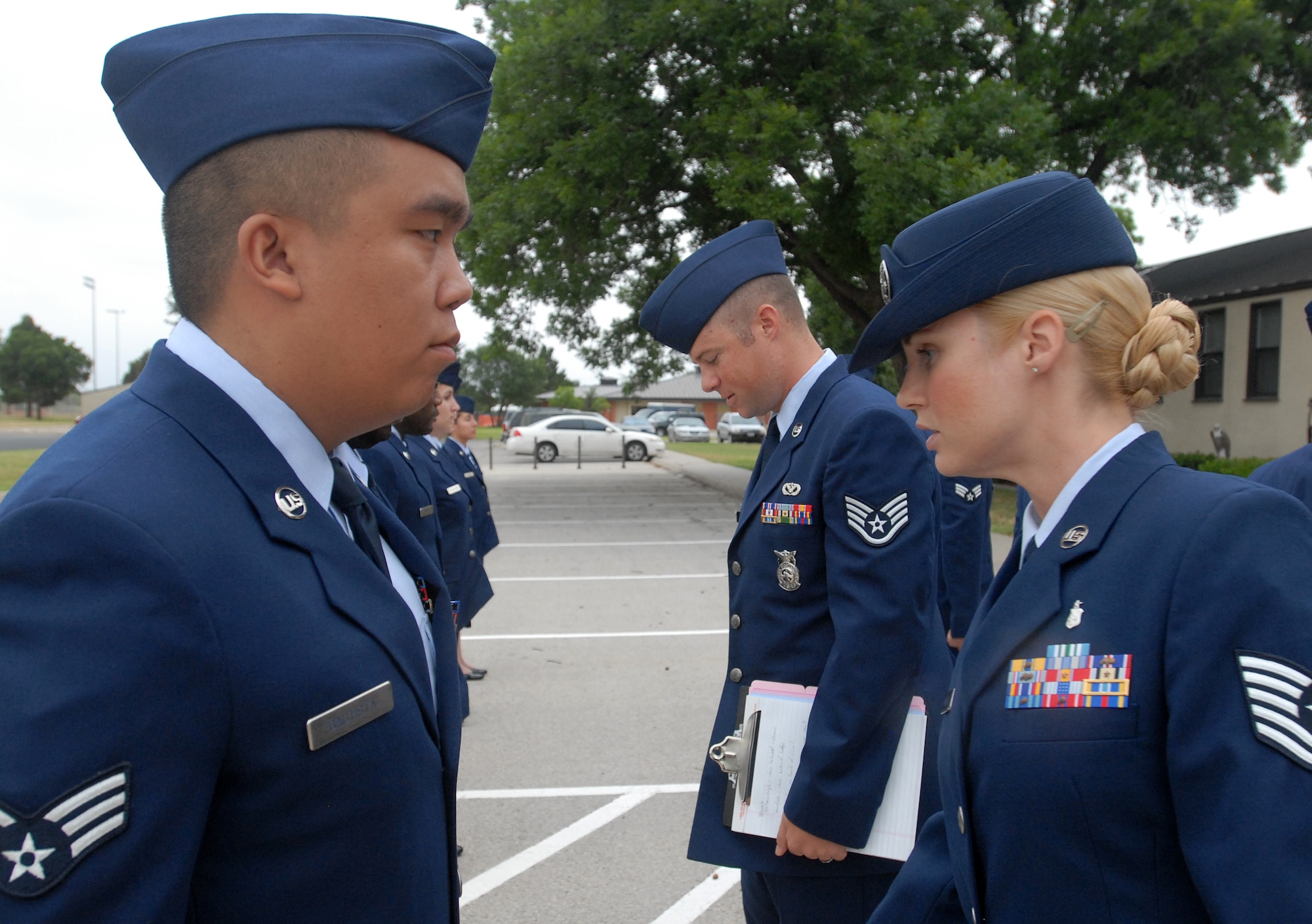Goodfellow Airman Leadership instructor, Tech Sgt. April Miller, and class leader, Staff Sgt. Anthony Fridley, conduct an open ranks inspection of Class  10-G1 in Service Dress June 14.  Uniform inspections are a key part of all enlisted professional military education and help to instill pride in the individual’s uniform. (U.S. Air Force photo/Master Sgt Randy Mallard)