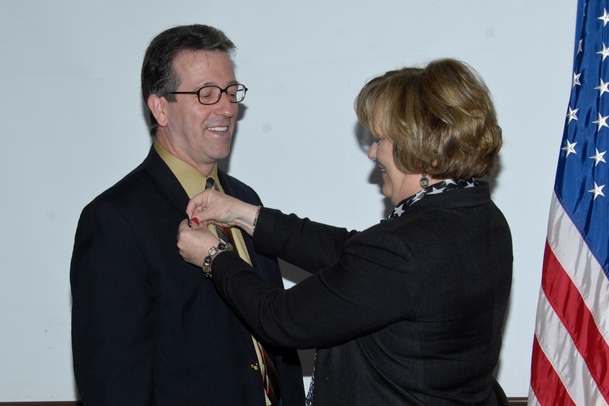 Electronic Systems Center Director of Personnel Sheila Brennan pins the Air Force civilian pin on Michael Boudreau during the civilian orientation course June 8. Hanscom's newset civilians now complete the required training for the pin during the orientation.  (U.S. Air Force photo by Linda Labonte Britt.)