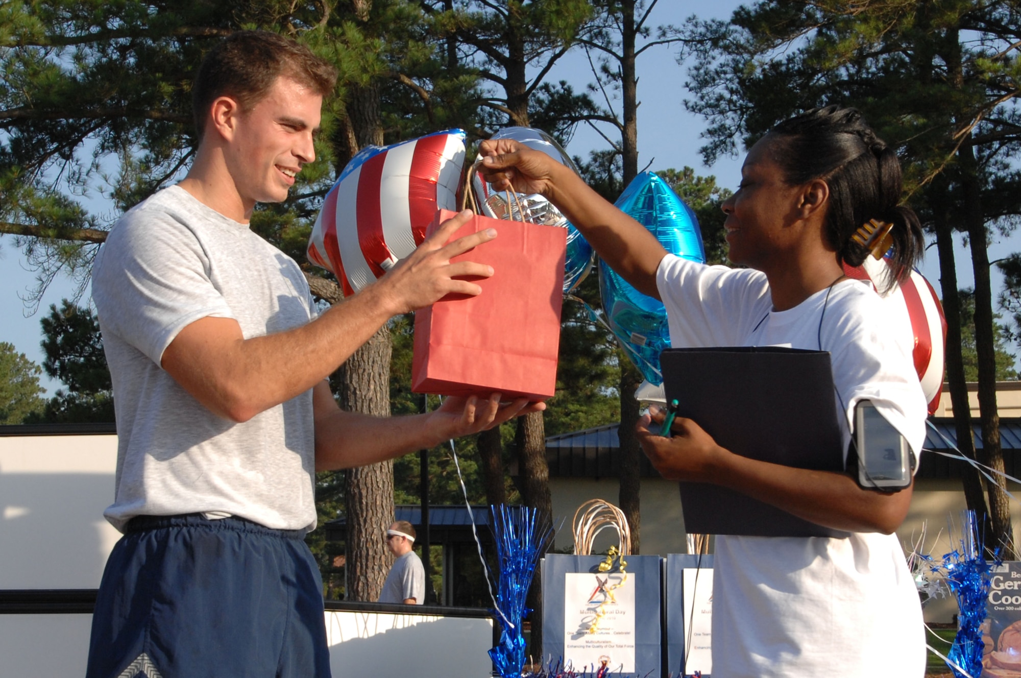 SEYMOUR JOHNSON AIR FORCE BASE, N.C. – Master Sgt. Carmia Basker hands Airman 1st Class Michael Giammo a gift bag for being the first runner to complete the Multicultural Day 2-mile run/walk June 11, 2010. Airman Giammo, 4th Comptroller Squadron budget technician, hails from Cleveland. Sergeant Basker, 4th Fighter Wing Equal Opportunity Office deputy director, is a native of Beaufort. (U.S. Air Force photo/Tech. Sgt. Tammie Moore)