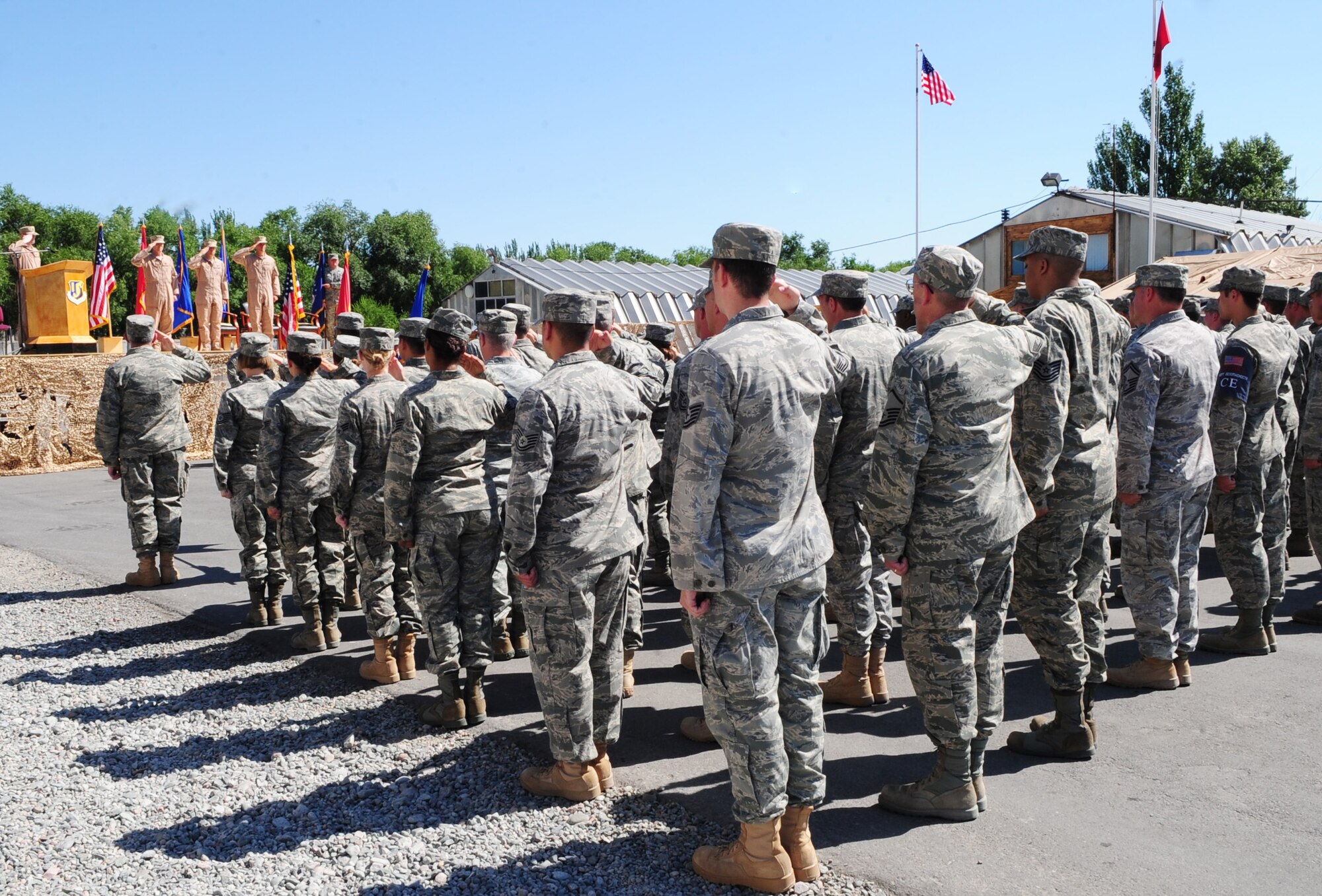 Airmen from the 376th Air Expeditionary Wing salute the flags during the playing of the U.S. and Kyrgyz national anthems during a change of command ceremony for the 376th AEW at the Transit Center at Manas, Kyrgyzstan, June 15, 2010.  Colonel Blaine D. Holt relinquished command of the 376th Air Expeditionary Wing to Col. Dwight C. Sones. Presiding over the change of command was Lt. Gen. Mike Hostage, Commander, U.S. Air Forces Central Command, Southwest Asia. (U.S. Air Force photo/ Senior Airman Nichelle Anderson/ released)
