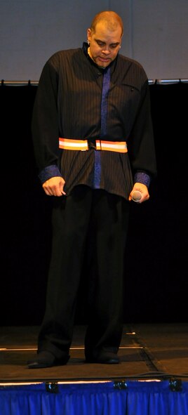 RAF MILDENHALL, England -- Comedian Sinbad, a former Air Force KC-135 boom operator, performs a comedy routine for Airmen at the Northside Fitness Center June 11.  During a bit making fun of reflective belts, someone in the crowd handed him one, which he used in the act.  (U.S. Air Force photo/Staff Sgt. Austin M. May)