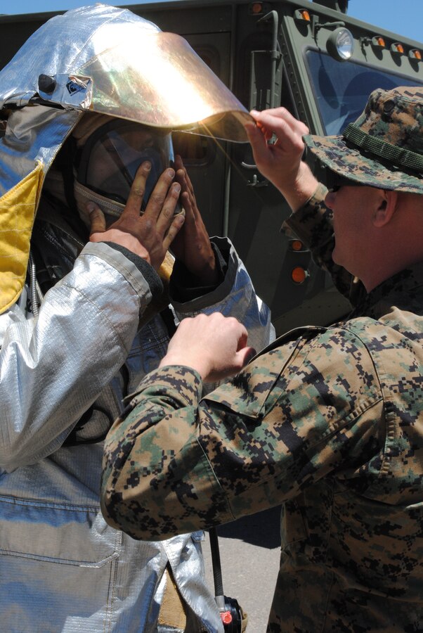 A Marine with Marine Wing Support Squadron 473, Crash Fire and Rescue, is checked for proper use of a bunker suit in a field training exercise, during Exercise Javelin Thrust 2010.
