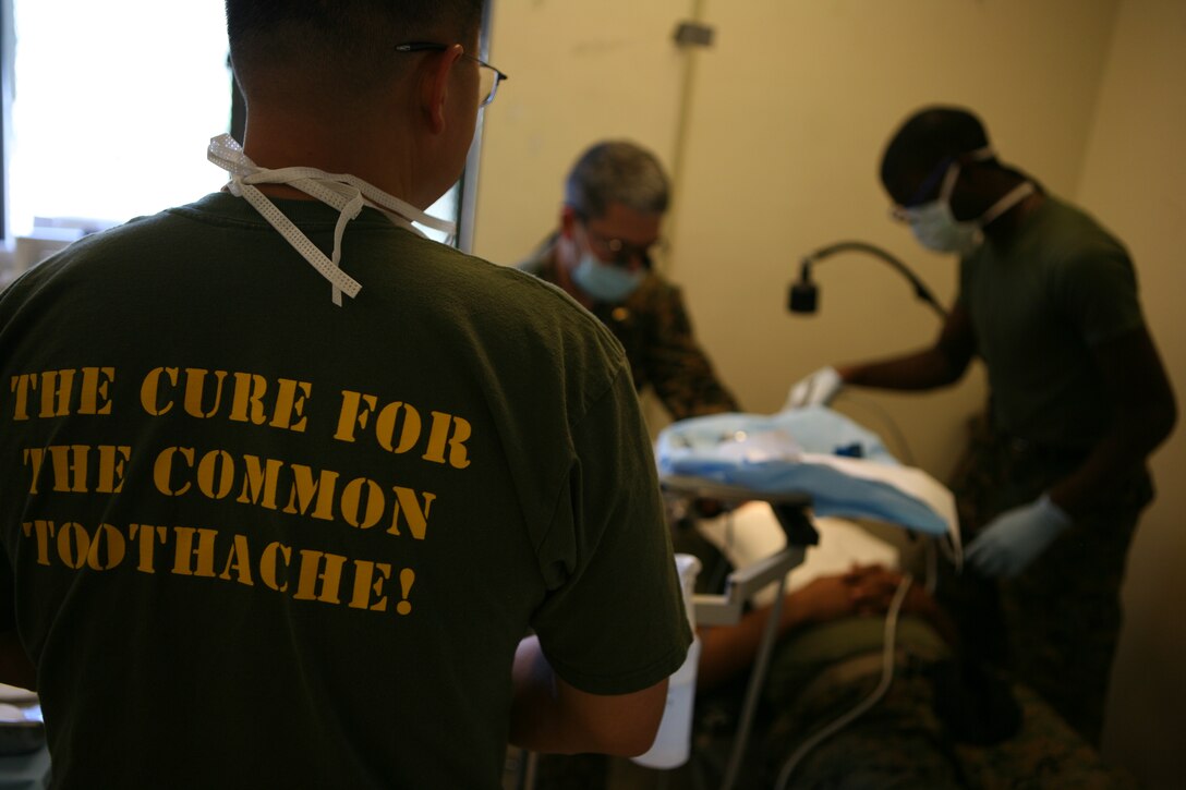 Dental staff with 4th Marine Logistics Group work to fill a patient's tooth during exercise Javelin Thrust 2010.
