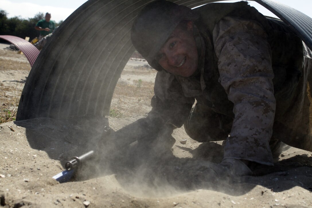 Timothy Isaly, assistant principal, Newman Smith High School, Carrollton, Texas, ducks and crawls while carrying a M-16A2 service rifle with a rubber bayonet attached to the end, while maneuvering through a tunnel as part of the Bayonet Assault Course on the depot.