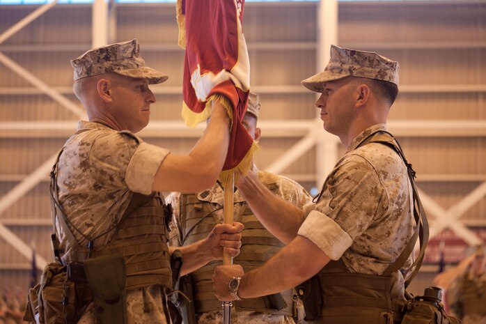 Lt. Col. Chris T. Pappas III, former Marine All-Weather Fighter Attack Squadron 242 commanding officer, passes the squadron guidon to Lt. Col. Richard Petersen, current VMFA(AW)-242 commanding officer, during a change-of-command ceremony at the VMF (AW)-242 hangar here June 15. Pappas is headed to Fort McNair, WashingtonD.C., where he will be attending Top Level School.