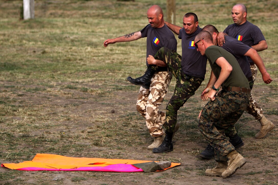 Romanian Army soldiers with the 341st Battalion, carry a simulated casualty to the landing zone during a Marine Corps Martial Arts Program physical training exercise at Babadag Training Area, Romania, June 16. The Romanians are training alongside the Marines and sailors of 1st Tank Bn.’s scout platoon, as well as Ukrainian Army soldiers with the 30th Mechanized Infantry Brigade as part of the third peacekeeping operation training course of Black Sea Rotational Force 2010.