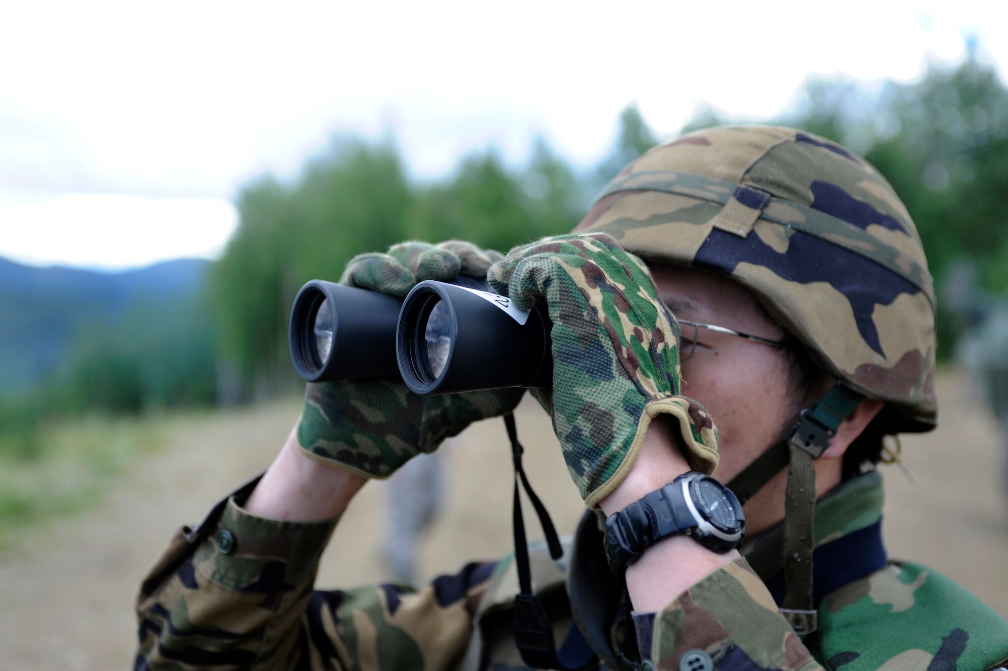 A Japanese Air Self-Defense Force service member looks through binoculars June 16, 2010, Eielson Air Force Base, Alaska. The JASDF member was searching for aircraft to fire a mock surface-to-air missile toward. This training operation was part of the joint multinational exercise Red Flag - Alaska. (U.S. Air Force photo/Airman 1st Class Willard E. Grande II)