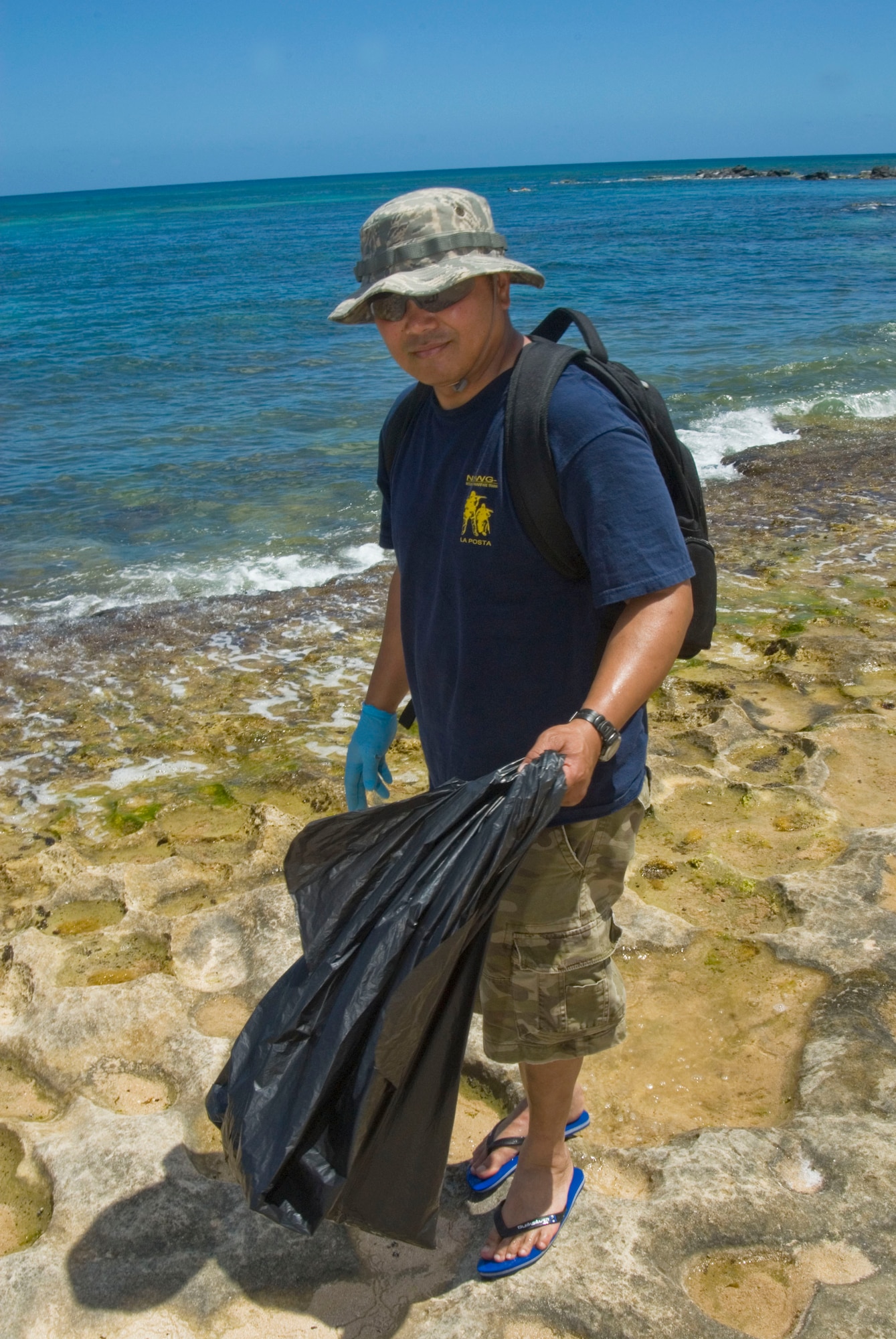 Tech. Sgt. Gil Vicente helps pick up trash at Laniakea Beach on Oahu’s North Shore June 11, 2010. The 146th AW Civil Engineering Squadron participated in the project alongside the organization “Malama nu Honu,” a non-profit group that works to protect the Hawaiian Green Sea Turtle through education, public awareness and conservation. (DoD photo by Airman 1st Class Nicholas Carzis, U.S. Air Force/Released)