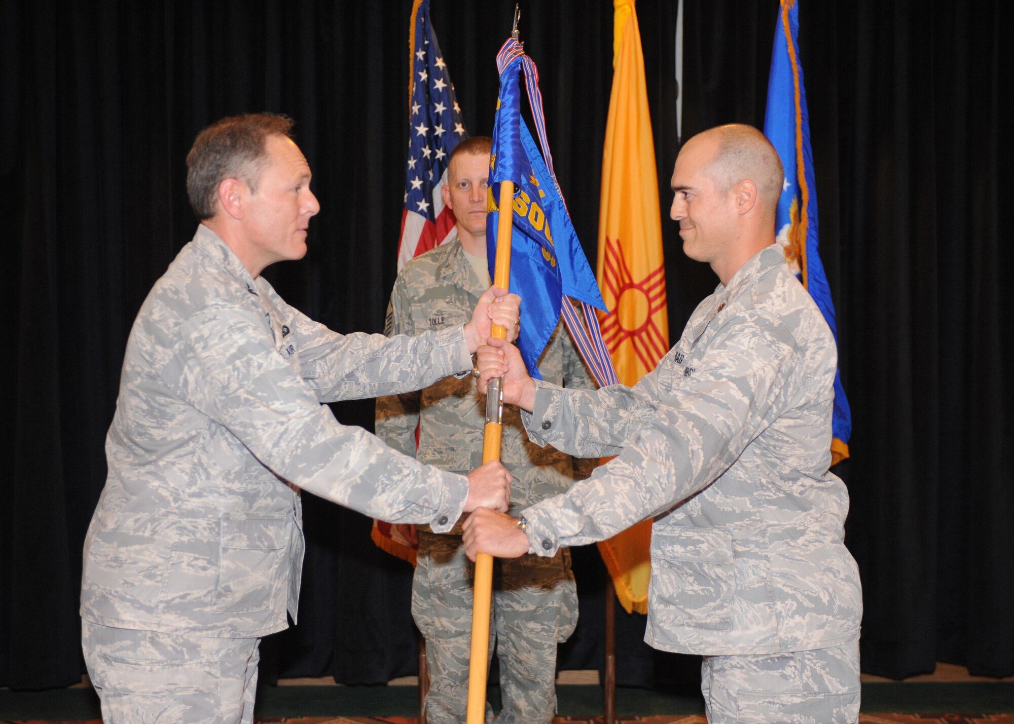 Col. Steven Kimball (left), 27th Special Operations Mission Support Group commander, presents Maj. Jason Virag, 27th Special Operations Communications Squadron incoming commander, with the squadron guidon, June 6. Lt. Col. Richard Jarrell relinquished command of the squadron after heading it since June 2008. (U.S. Air Force photo by Airman 1st Class Maynelinne De La Cruz) 