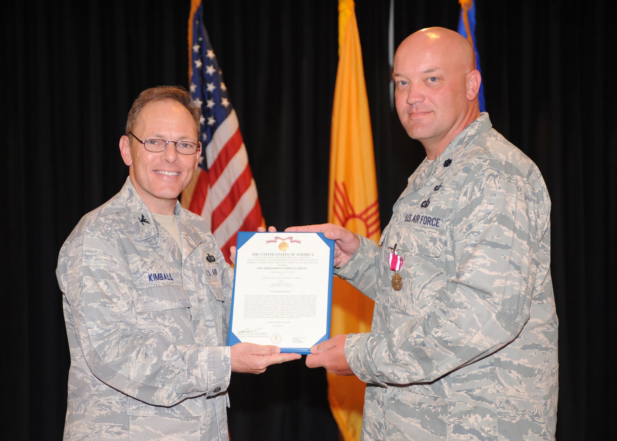 Col. Steven Kimball, 27th Special Operations Mission Support Group commander, presents Lt. Col. Richard Jarrell, outgoing commander of the 27th Special Operations Communication Squadron, with the Meritorious Service Medal, June 6. Colonel Jarrell received his award during the 27th Special Operations Communication Squadron Change of Command. (U.S. Air Force photo by Airman 1st Class Maynelinne De La Cruz)