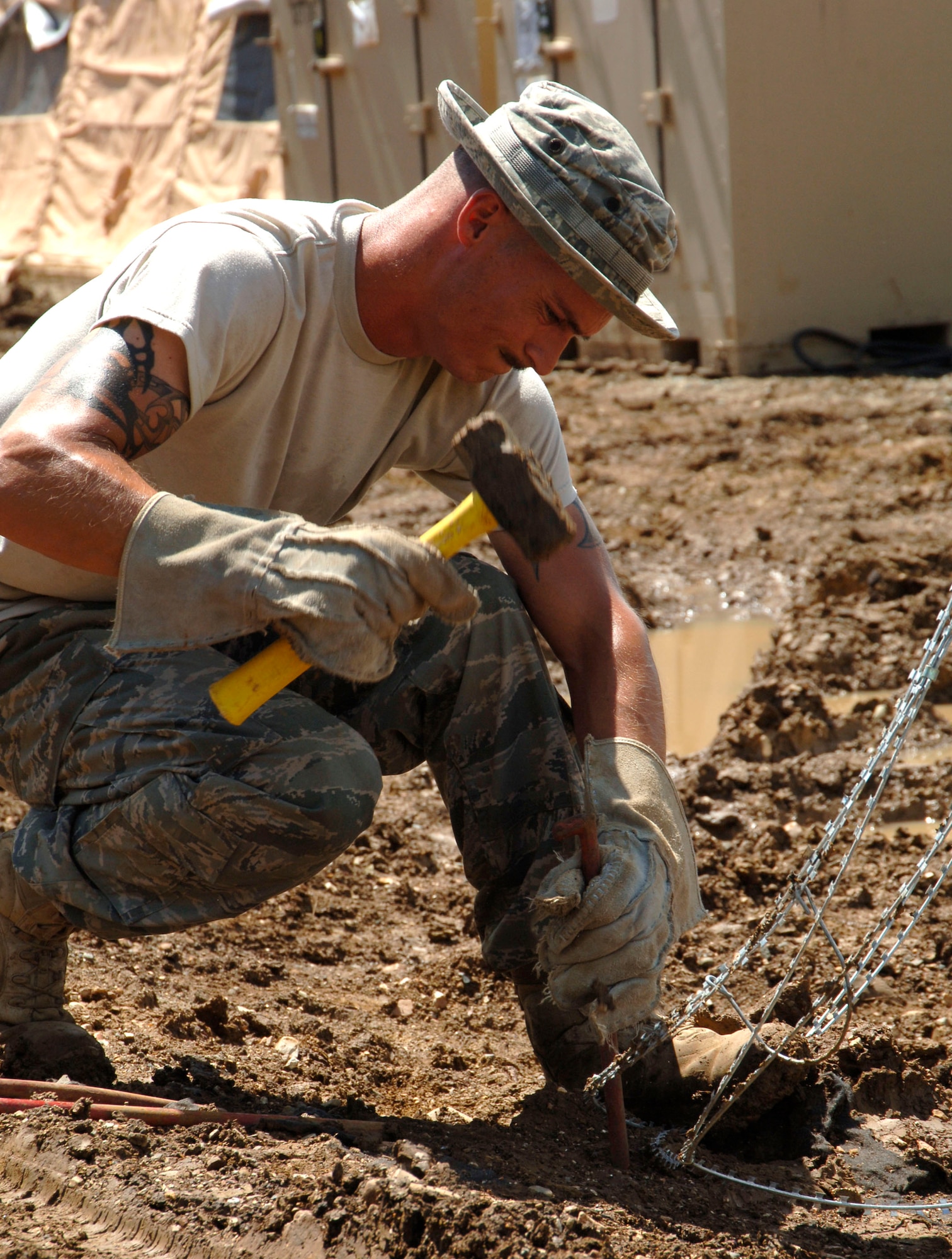 Staff Sgt. Patrick Hesckett, 355th Security Forces Squadron, stakes concertina wire in place around the temporary encampment that will house more than 250 Airmen, Soldiers, and Marines for New Horizons Panama 2010. (U.S. Air Force photo/Tech. Sgt. Eric Petosky)