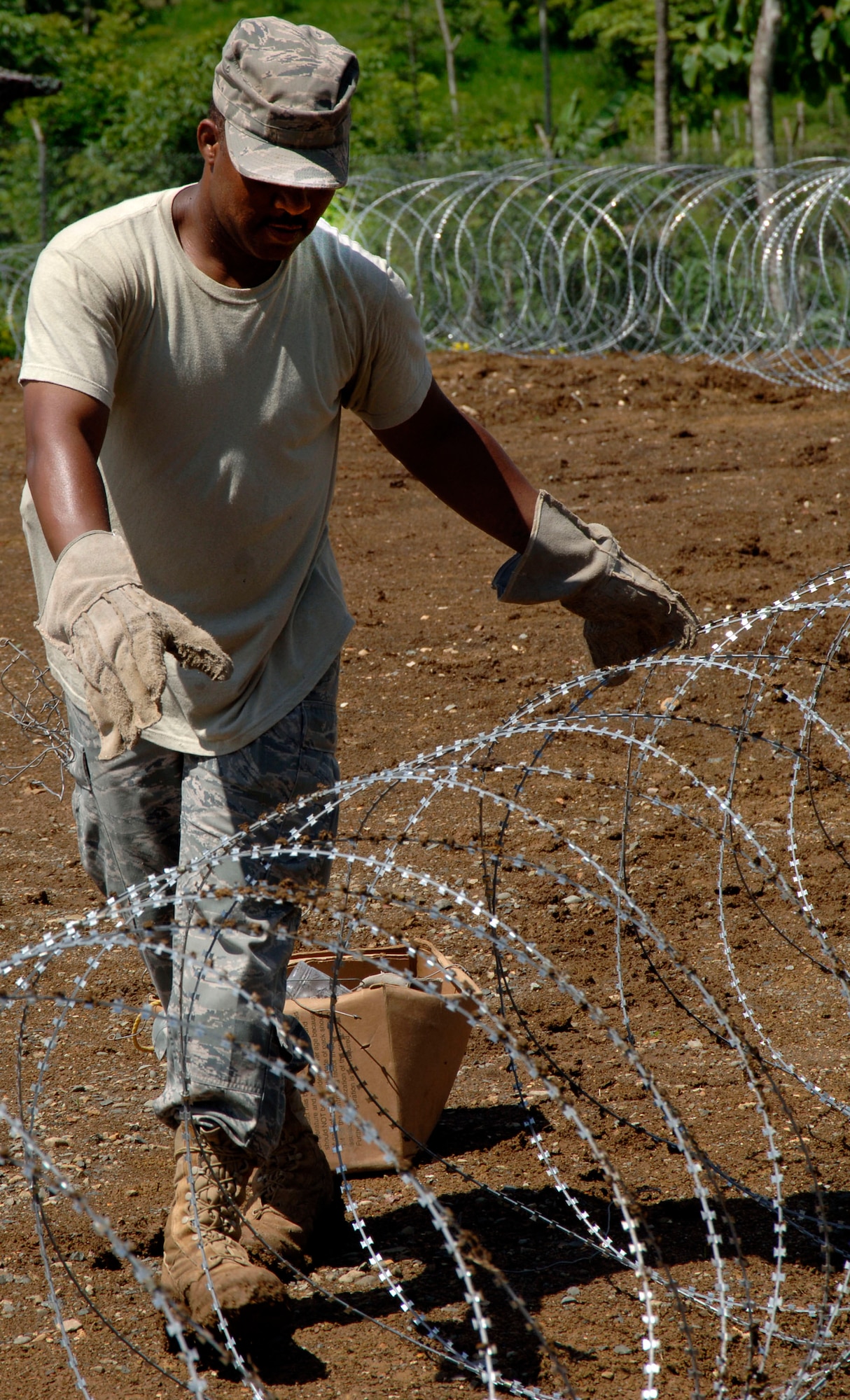 Master Sgt. Benny Baker, 12th Air Force (Air Forces Southern), places concertina wire around the temporary encampment that will house more than 250 Airmen, Soldiers, and Marines for New Horizons Panama 2010. (U.S. Air Force photo/Tech. Sgt. Eric Petosky)