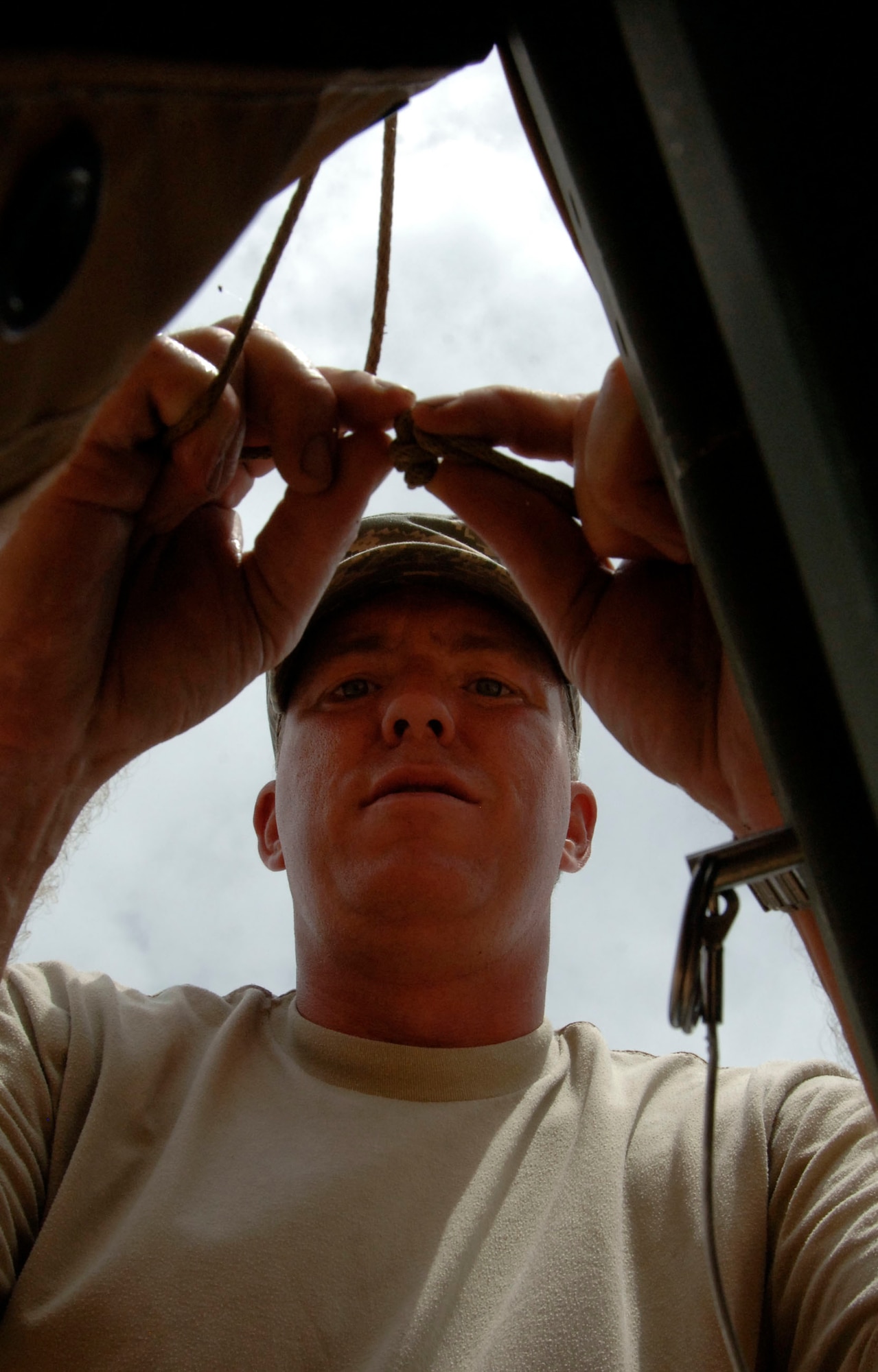 Tech. Sgt. Dave Gibbs, 49th Materiel Maintenance Group, laces together the roof of the dining tent at the temporary encampment that will house more than 250 Airmen, Soldiers, and Marines for New Horizons Panama 2010. (U.S. Air Force photo/Tech. Sgt. Eric Petosky)