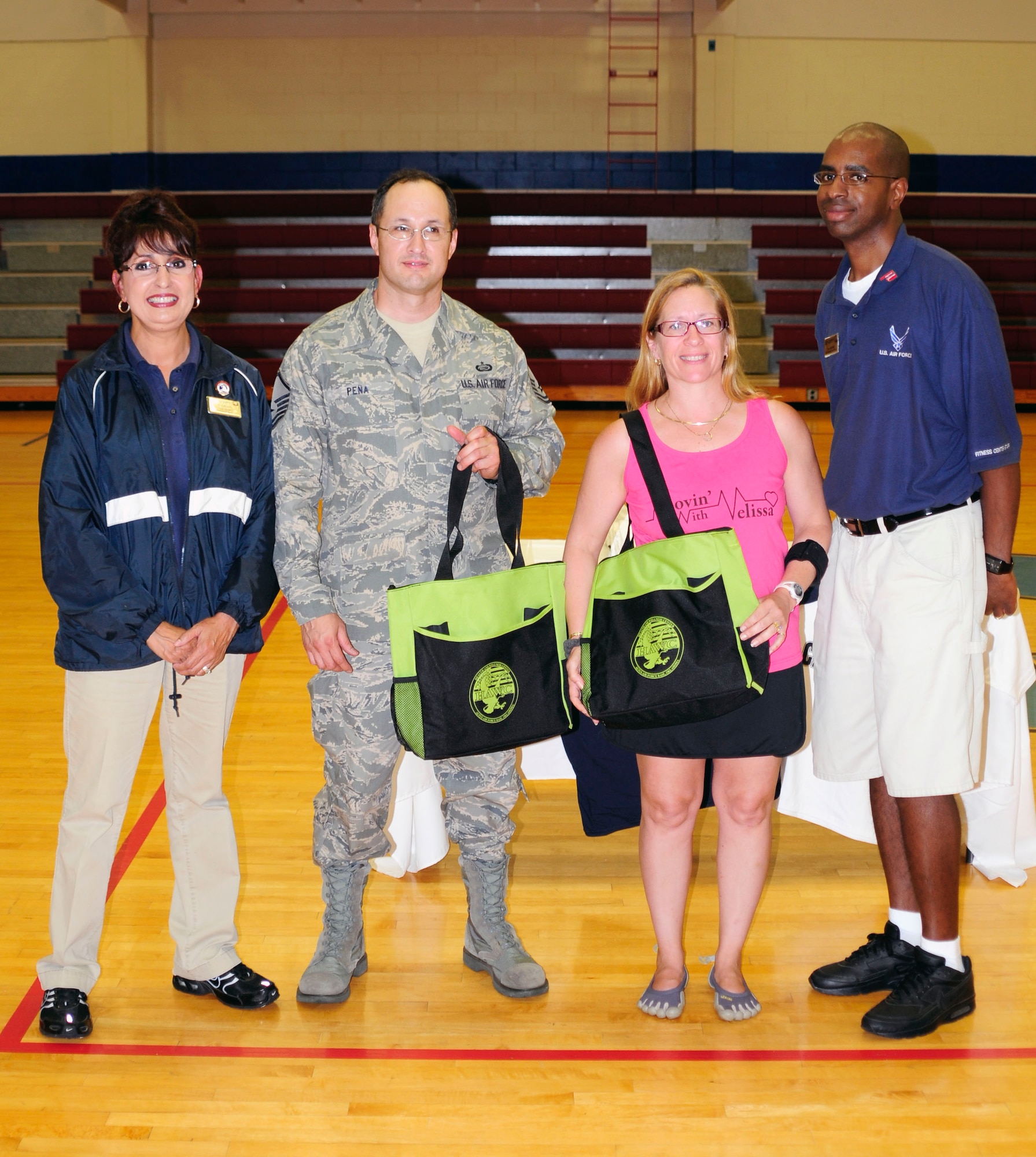 ALTUS AFB, Okla.- U.S. Air Force Master Sgt. Corando Pena and Mrs. Mellissa Guinan are presented with Health and Wellness Center (HAWC) bags as a rewarded for being the first male and female to finish their portion of the annual 1,000,000 push-up and crunch challenge.  A total of 19 teams consisting of 10 participants joined in effort to overcome the challenge and finished with approximately 1,480,000 push-ups and crunches.(U.S. Air Force photo by Airman1st Class Myles Stepp/ Released 97 AMW Public Affairs)