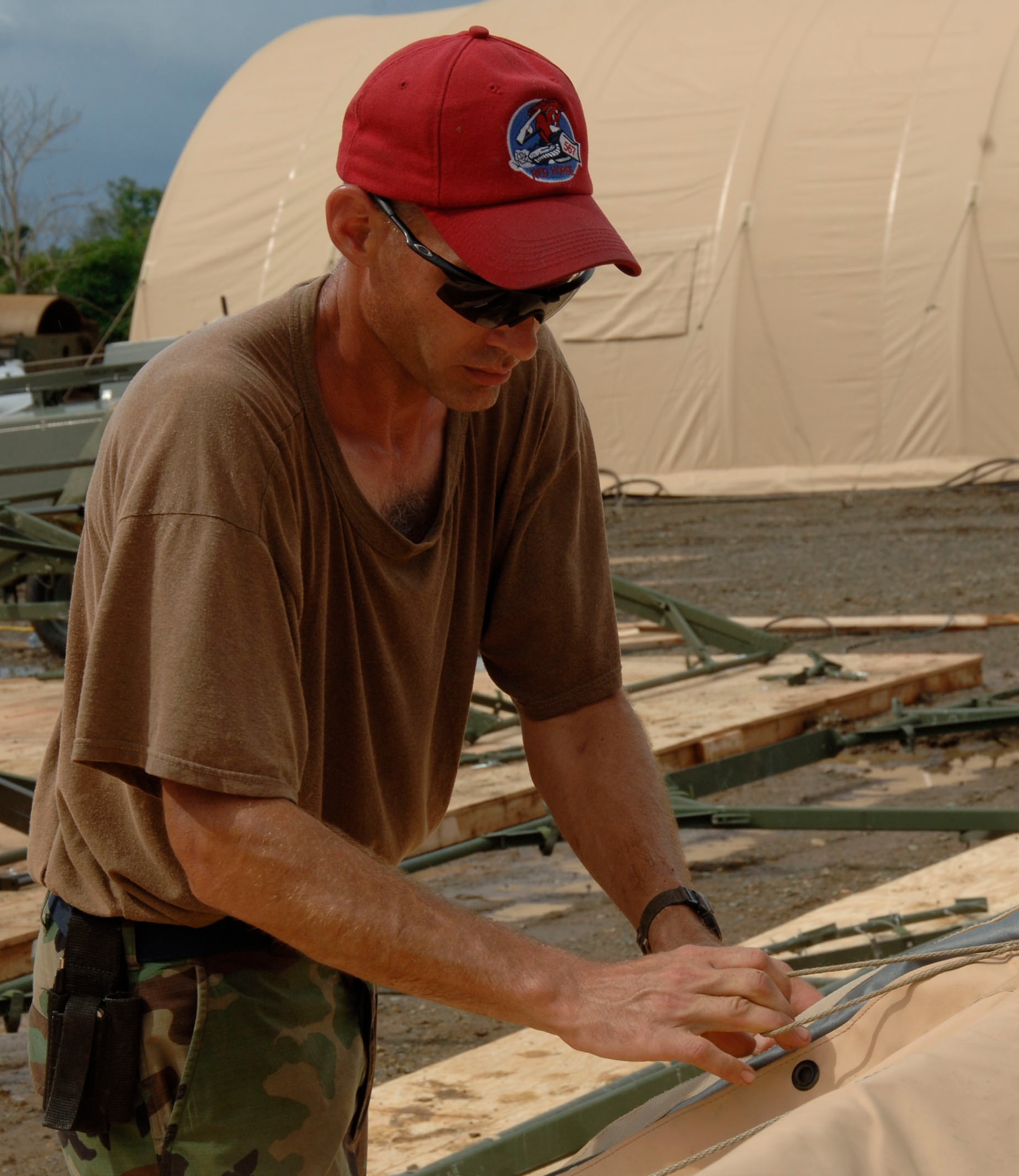 Master Sgt. Daniel Connolly, 567th RED HORSE Squadron, laces a roof section together for the dining tent at the temporary encampment that will house more than 250 Airmen, Soldiers, and Marines for New Horizons Panama 2010. (U.S. Air Force photo/Tech. Sgt. Eric Petosky)