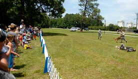 The 628th Security Forces Squadron K-9 section demonstrate how handlers use dogs to chase down and restrain suspects until the handler can regain control of the situation. The demonstration was initiated with a simulated firefight followed by the handler giving the command to the K-9 to take down the armed suspect. Military working dogs can have a bite force of up to 2,500 pounds per square inch of pressure when they take down a suspect. (U.S. Air Force photo/Senior Airman Timothy Taylor)