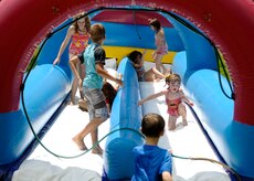 Children take a break from the sweltering heat in a cool slip and slide at the annual base picnic June 11, 2010 on Joint Base Charleston, S.C. The two-day annual picnic ran from June 11 to June 12 showcasing entertainment and activities from a local band, "The Blue Dogs," to slip and slides and giant inflatable jumpers for the kids. (U.S. Air Force photo/Senior Airman Timothy Taylor) 