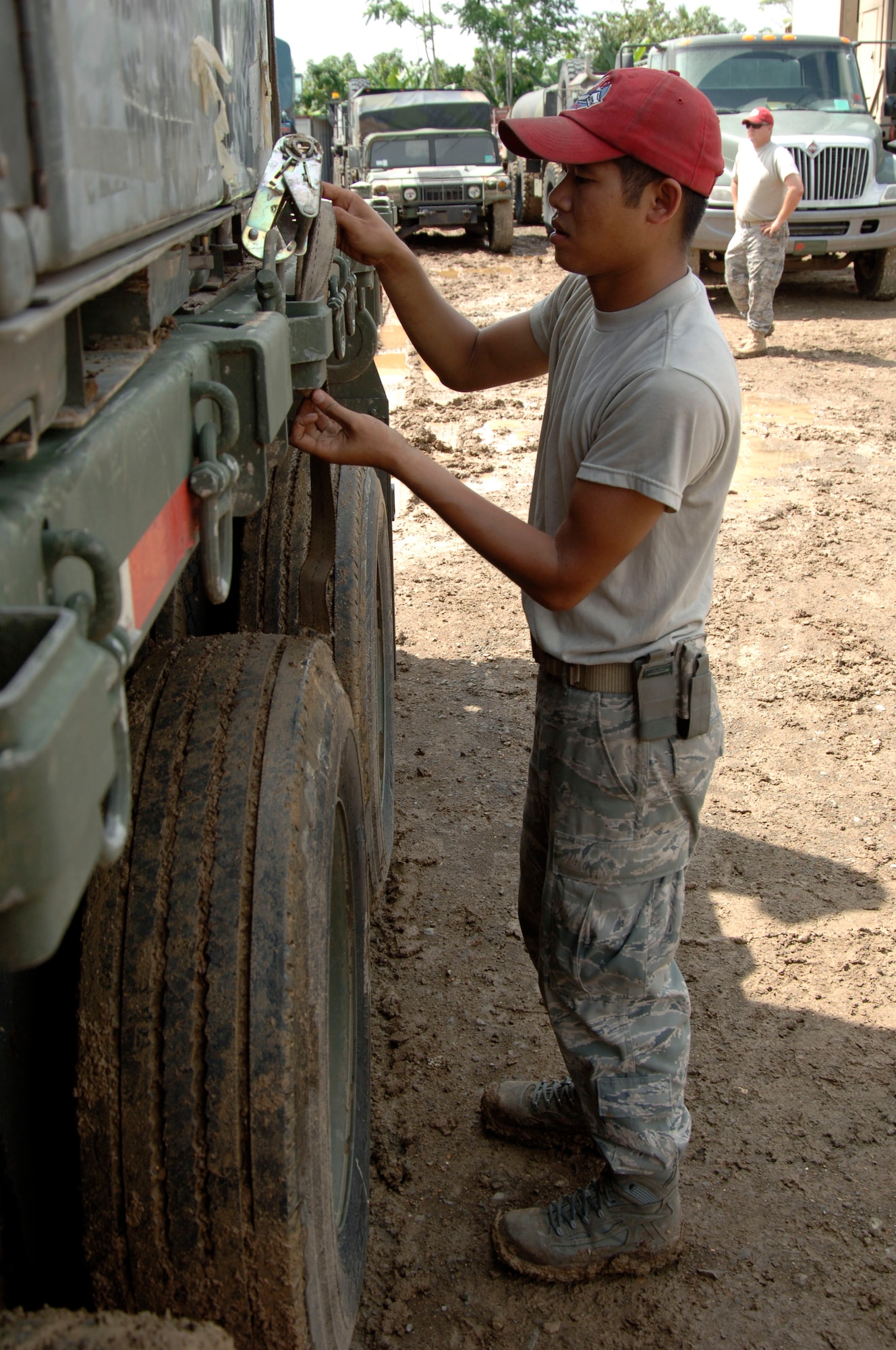 Staff Sgt. Phanomphone Phimmasone, 820th RED HORSE Squadron, secures a cargo container to a flatbed truck destined for the temporary encampment that will house more than 250 Airmen, Soldiers, and Marines for New Horizons Panama 2010. (U.S. Air Force photo/Tech. Sgt. Eric Petosky)