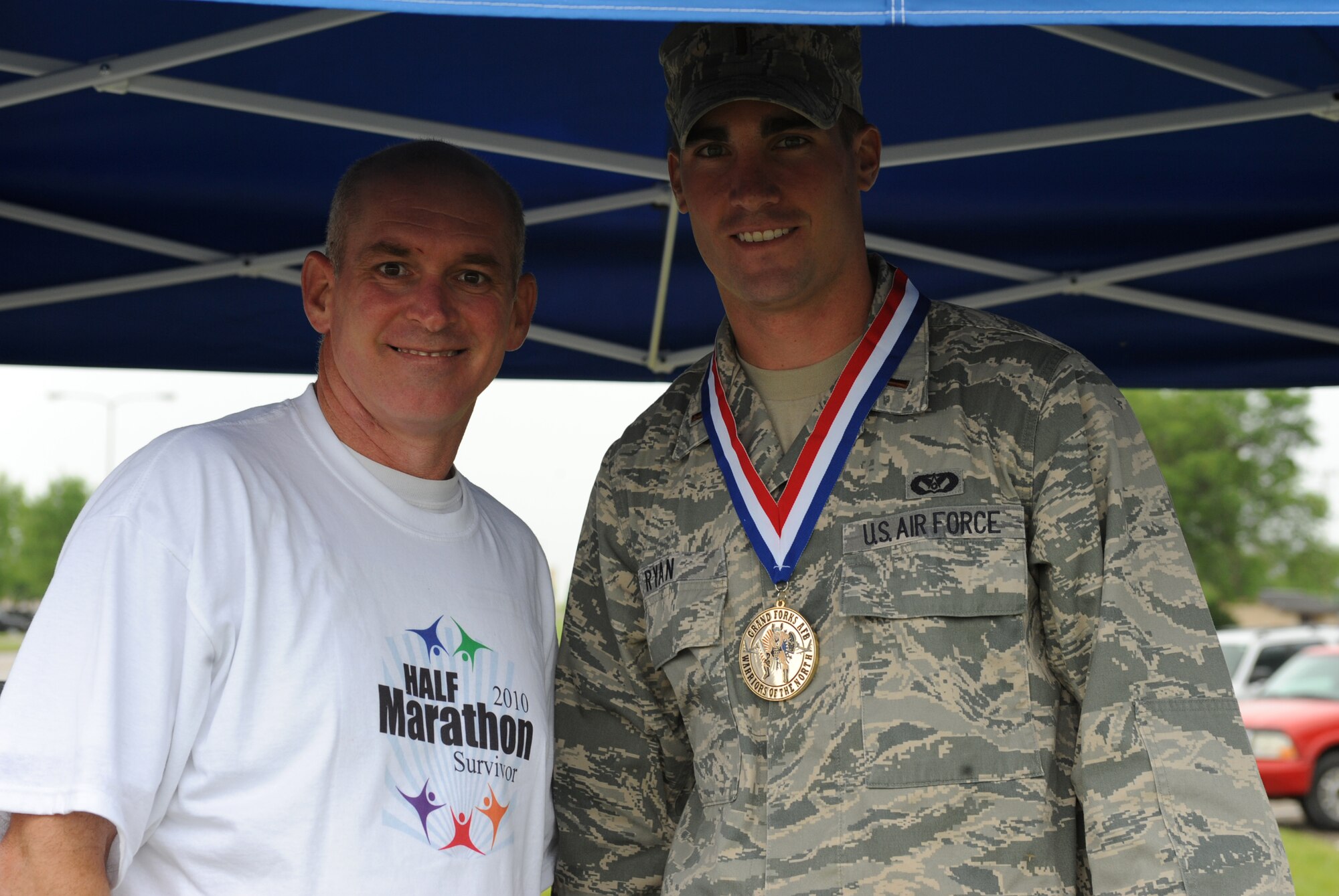 Col. John Quinn, 319th Air Refueling Wing vice-commander and 2nd Lt. Miles Ryan, 319th Civil Engineer Squadron (from left to right), pose for a picture after Colonel Quinn awarded Lieutenant Ryan first place in the male category for the Grand Forks Air Force Base Half-Marathon, June 15. Lieutenant Ryan tied for first place with Mr. Jeff Rosen, 319 CES, with a winning time of one hour, 37 minutes and 43 seconds. (U.S. Air Force photo by Airman 1st Class Amber Price)