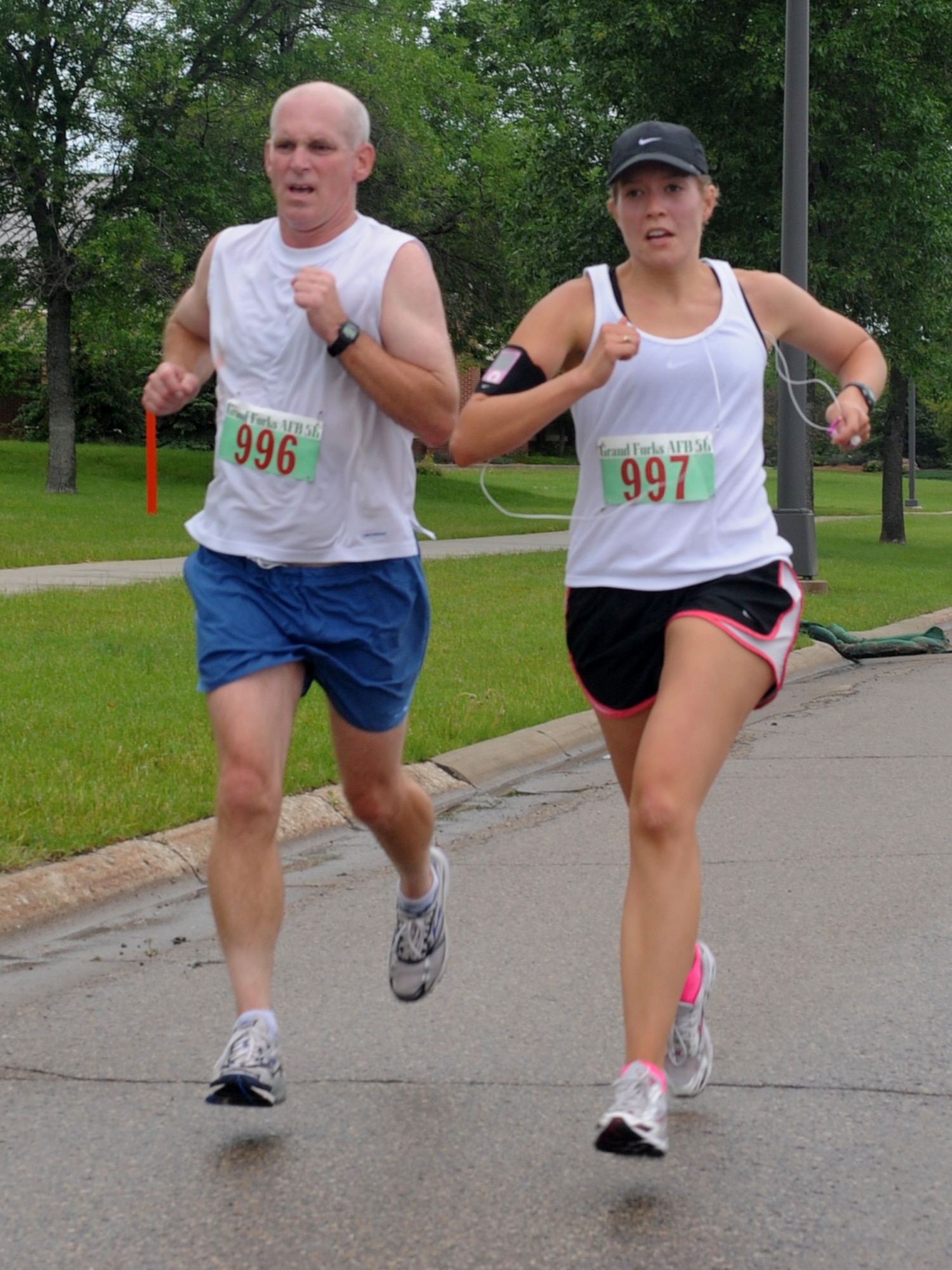 Col. John Quinn, 319th Air Refueling Wing vice-commander and 2nd Lt. Anna Hall, 319th Operations Support Squadron (from left to right), see the finish line during the Grand Forks Air Force Base Half-Marathon, June 15. This marathon is just one of the Fitness Center’s special events that are held every year. (U.S. Air Force photo by Airman 1st Class Amber Price)